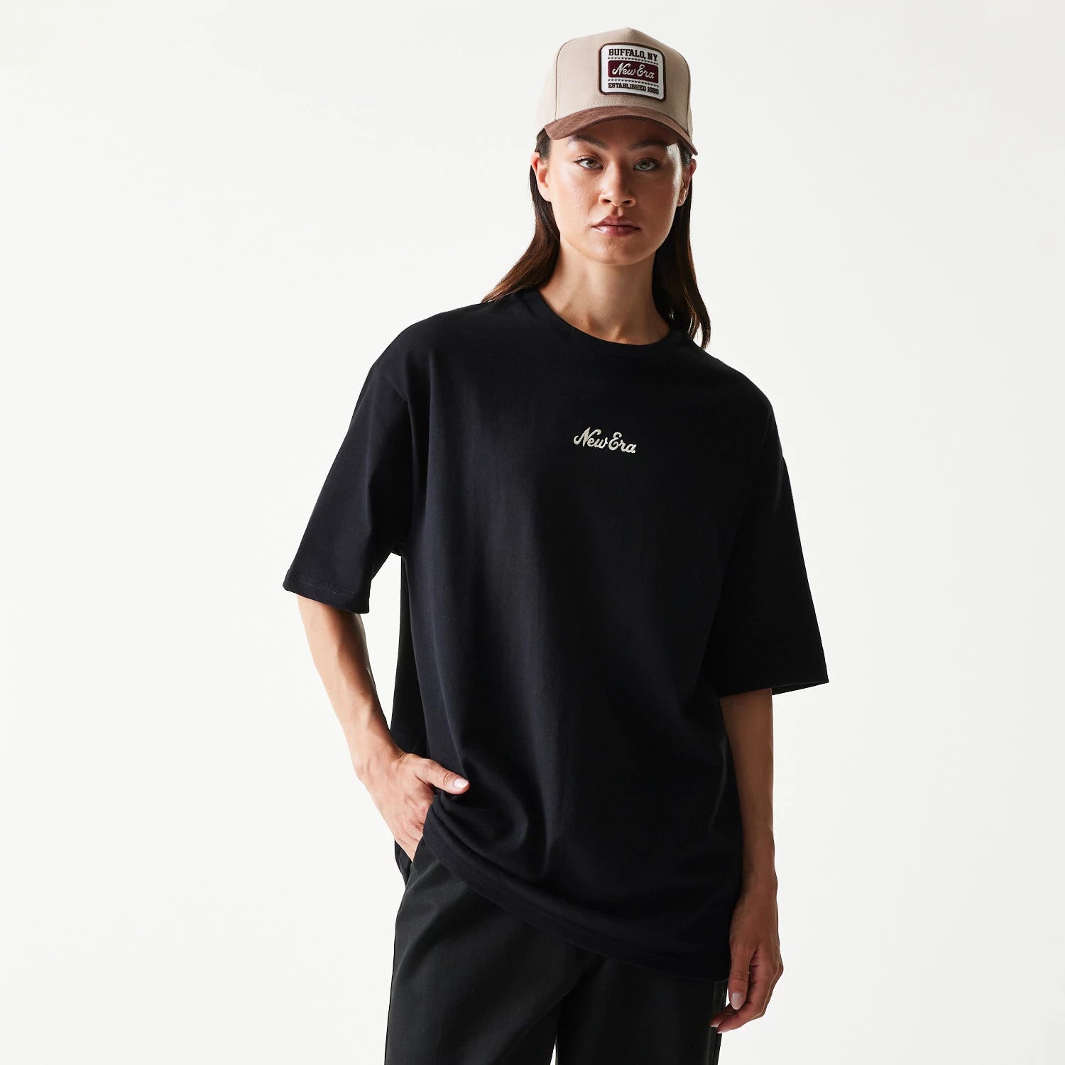 The model is wearing this New Era Heritage Script T-Shirt in black. 4