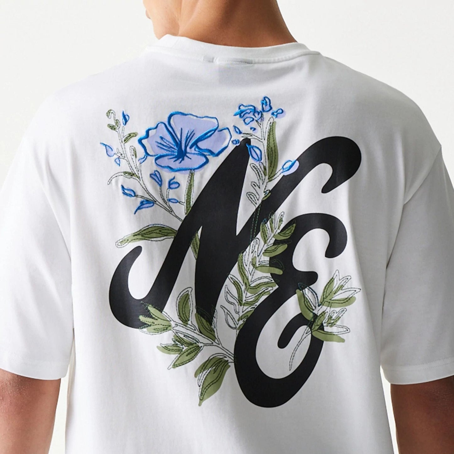 The model is wearing this New Era Floral Graphic Oversized T-Shirt in white. 8