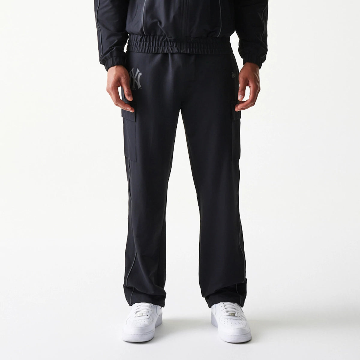 New Era New York Yankees MLB Utility Black Straight Leg Cargo Joggers, front view on a model showcasing the elastic waistband, two side cargo pockets, and the Yankees logo on the right upper leg, complementing the black fabric.