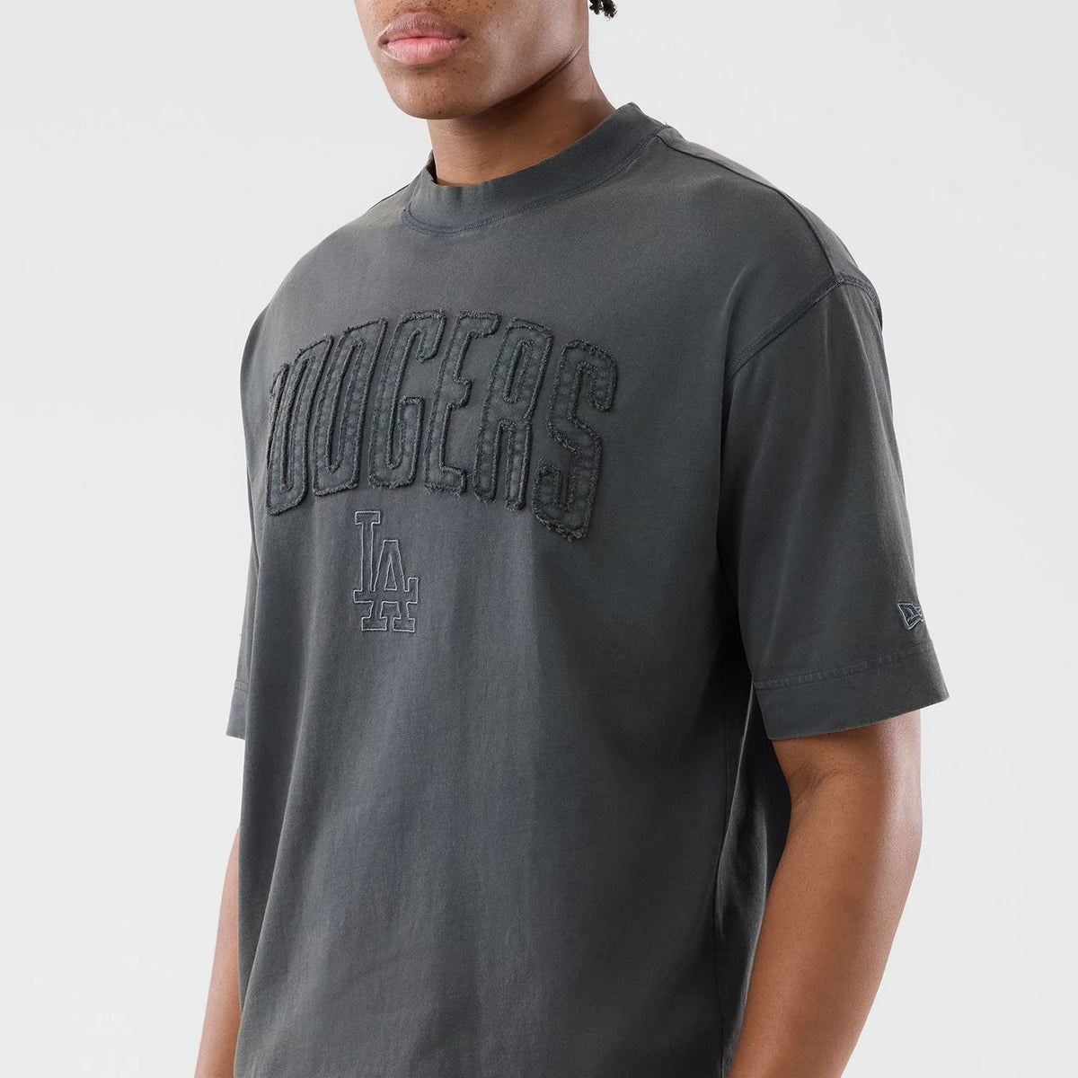 New Era LA Dodgers MLB Washed Dark Grey T-Shirt, front three-quarter view showing large black embroidered Dodgers lettering across the chest, a smaller embroidered LA logo below, and the New Era logo embroidered on the left sleeve.