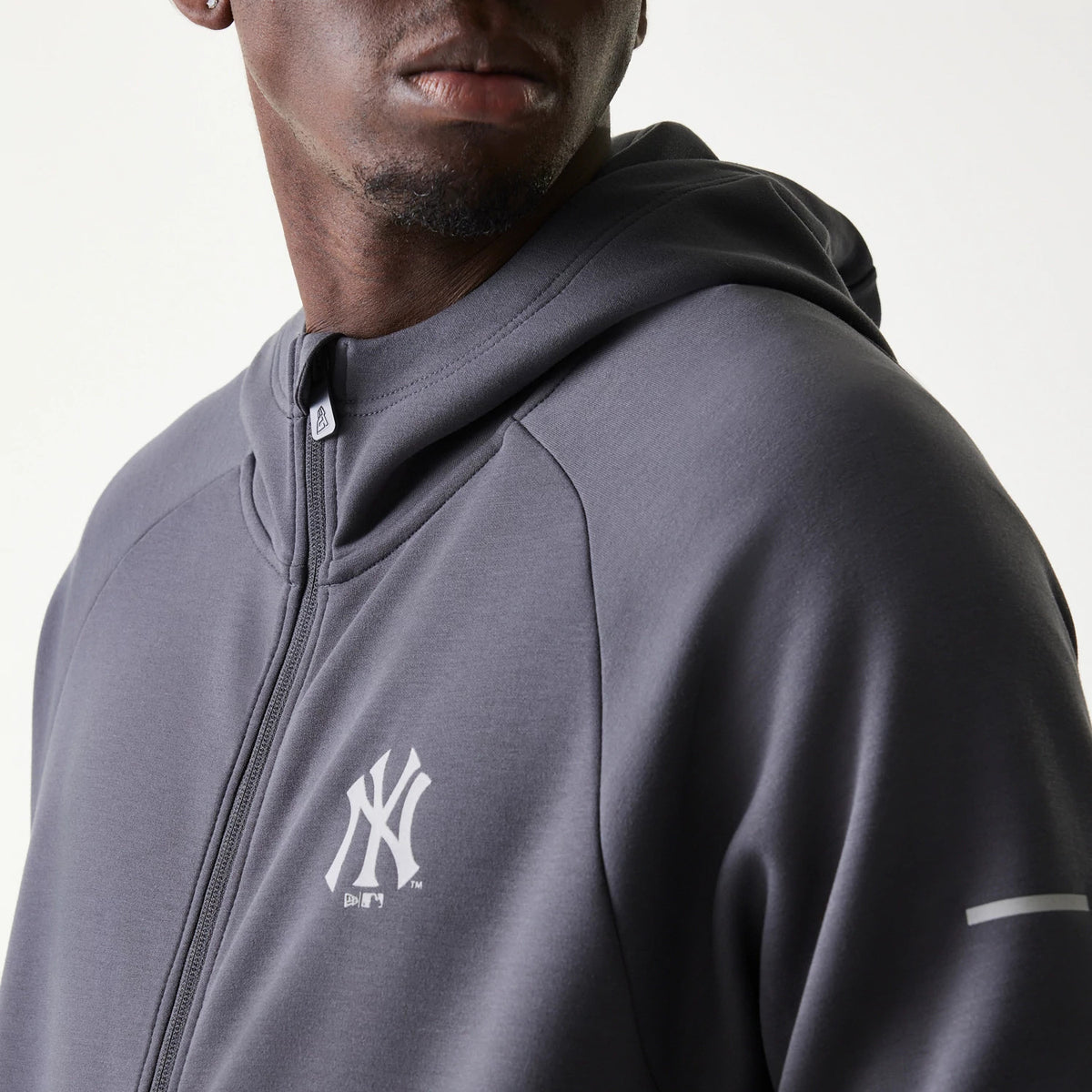 New Era New York Yankees MLB Dark Grey Full Zip Hoodie, front view on-model highlighting the embroidered white Yankees logo on the left chest, a full zip closure, and the hood extending from the collar.