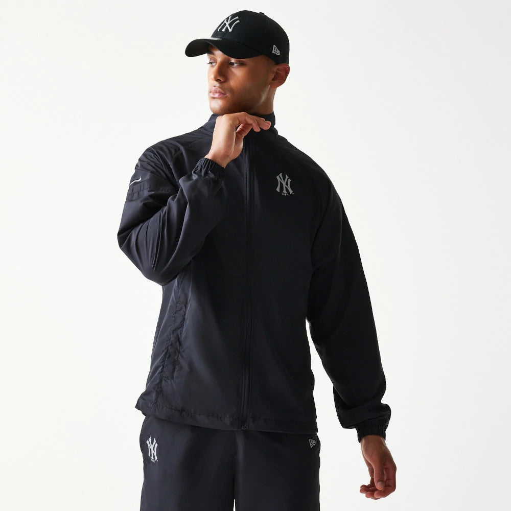 The model is wearing this MLB Reflective Strip New York Yankees Jacket in black. 1