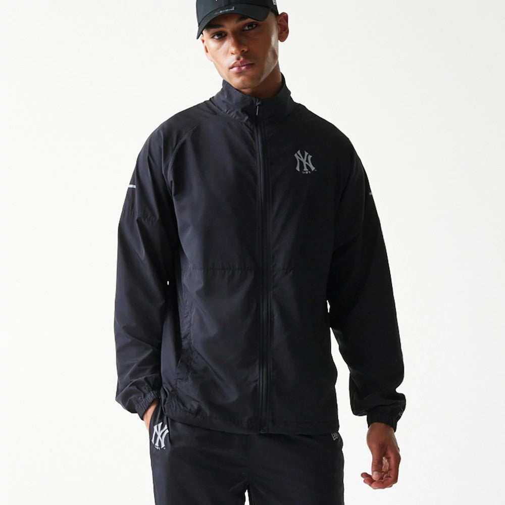 New Era New York Yankees MLB Reflective Strip Black Jacket, front view on-model showing the full zip closure, raised New York Yankees logo on the left chest, reflective strip on the left arm, and elastic cuffs.
