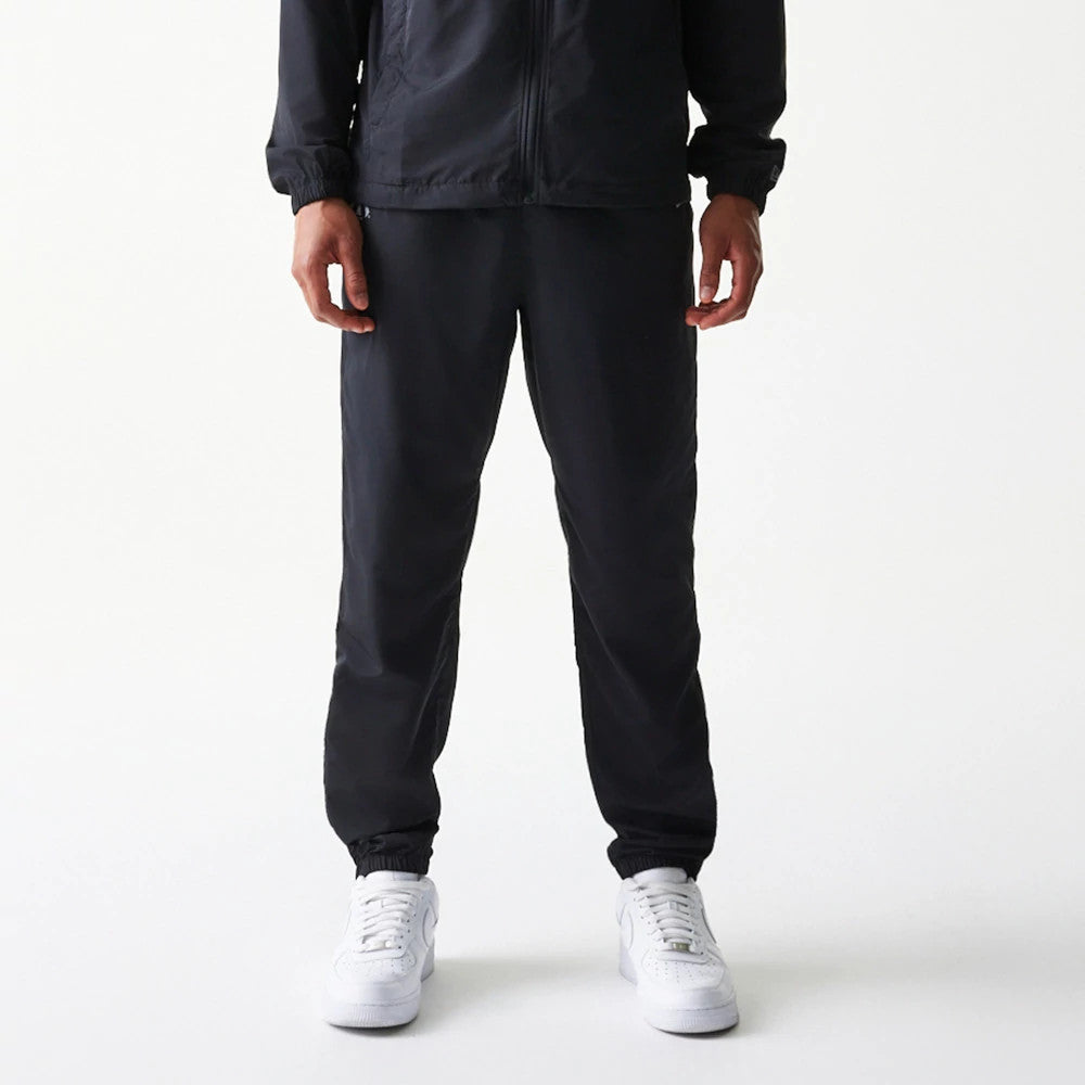 The model is wearing this MLB Reflective Logo New York Yankees Track Pants in black. 1