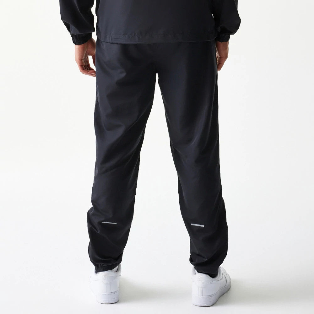The model is wearing this MLB Reflective Logo New York Yankees Track Pants in black. 2