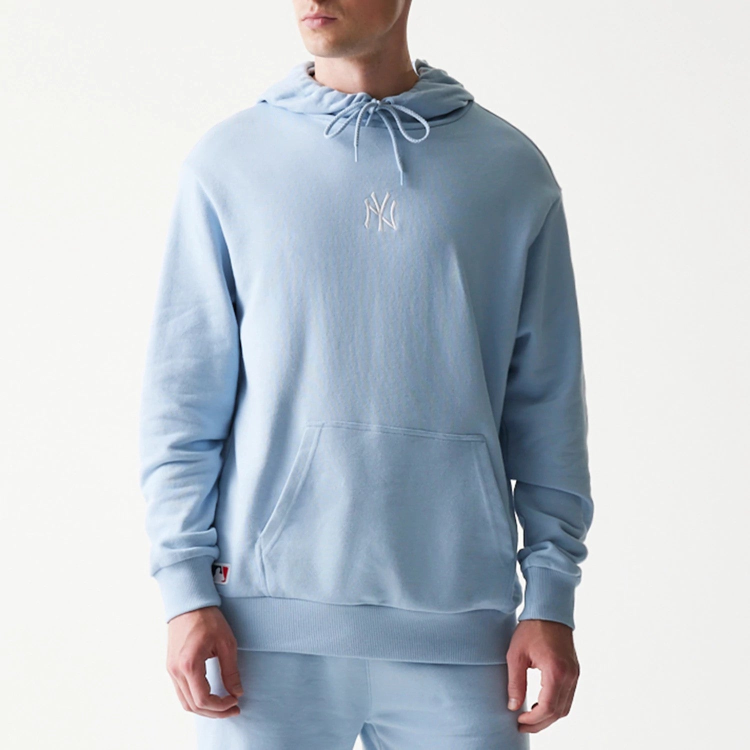 The model is wearing this MLB League Essential Midi New York Yankees Oversized Pullover Hoodie in pastel blue. 3