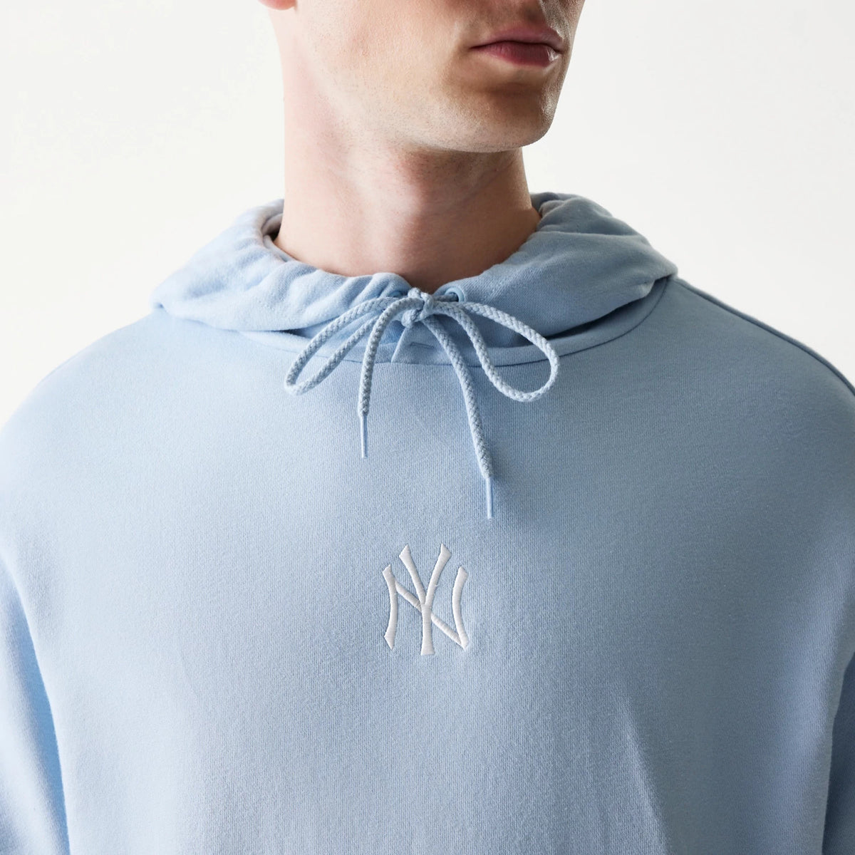 The model is wearing this MLB League Essential Midi New York Yankees Oversized Pullover Hoodie in pastel blue. 4