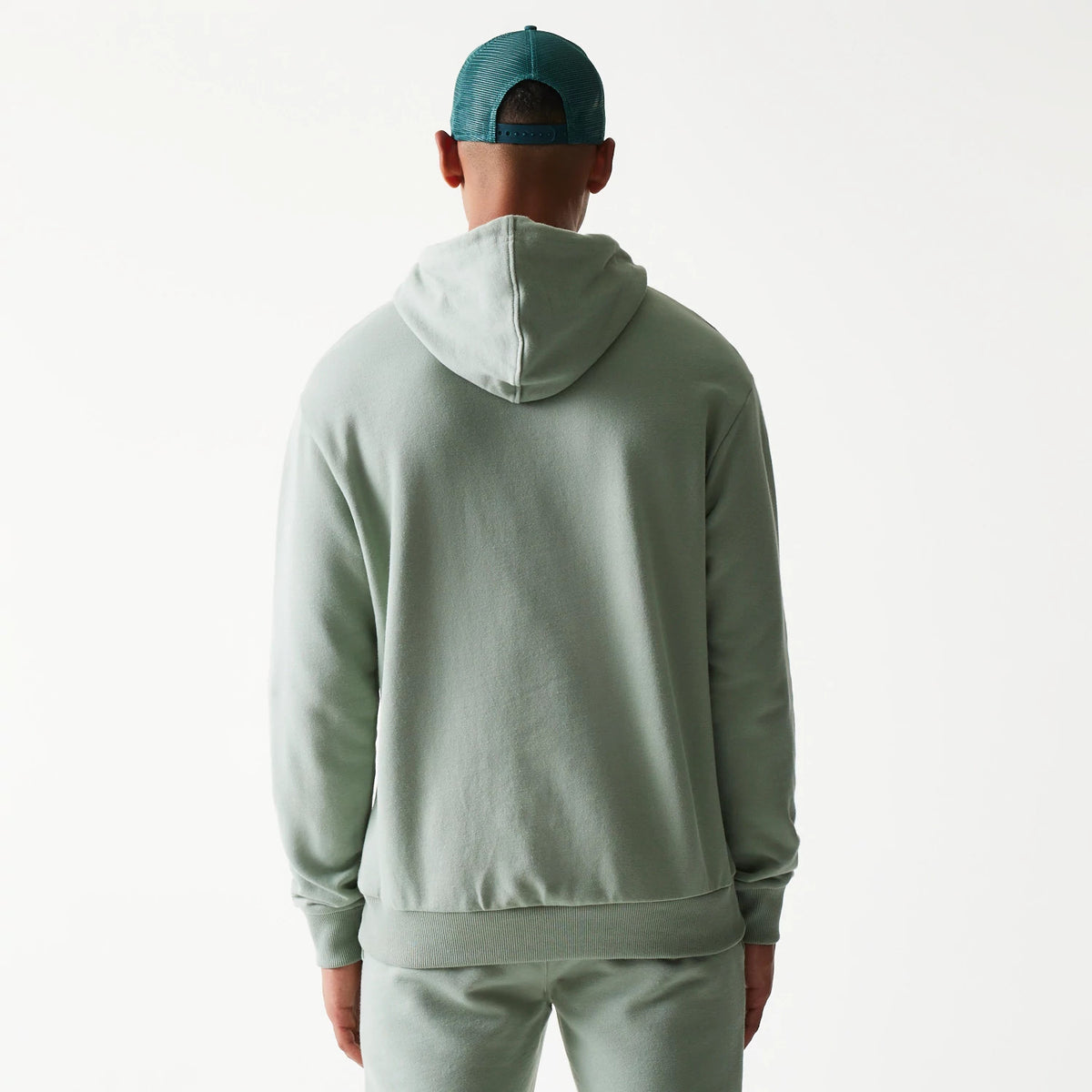 New Era LA Dodgers MLB Midi Green Oversized Pullover Hoodie, back view on a model showing the plain green fabric with a relaxed fit, hood resting on the shoulders and ribbed cuffs at the wrists and hem.
