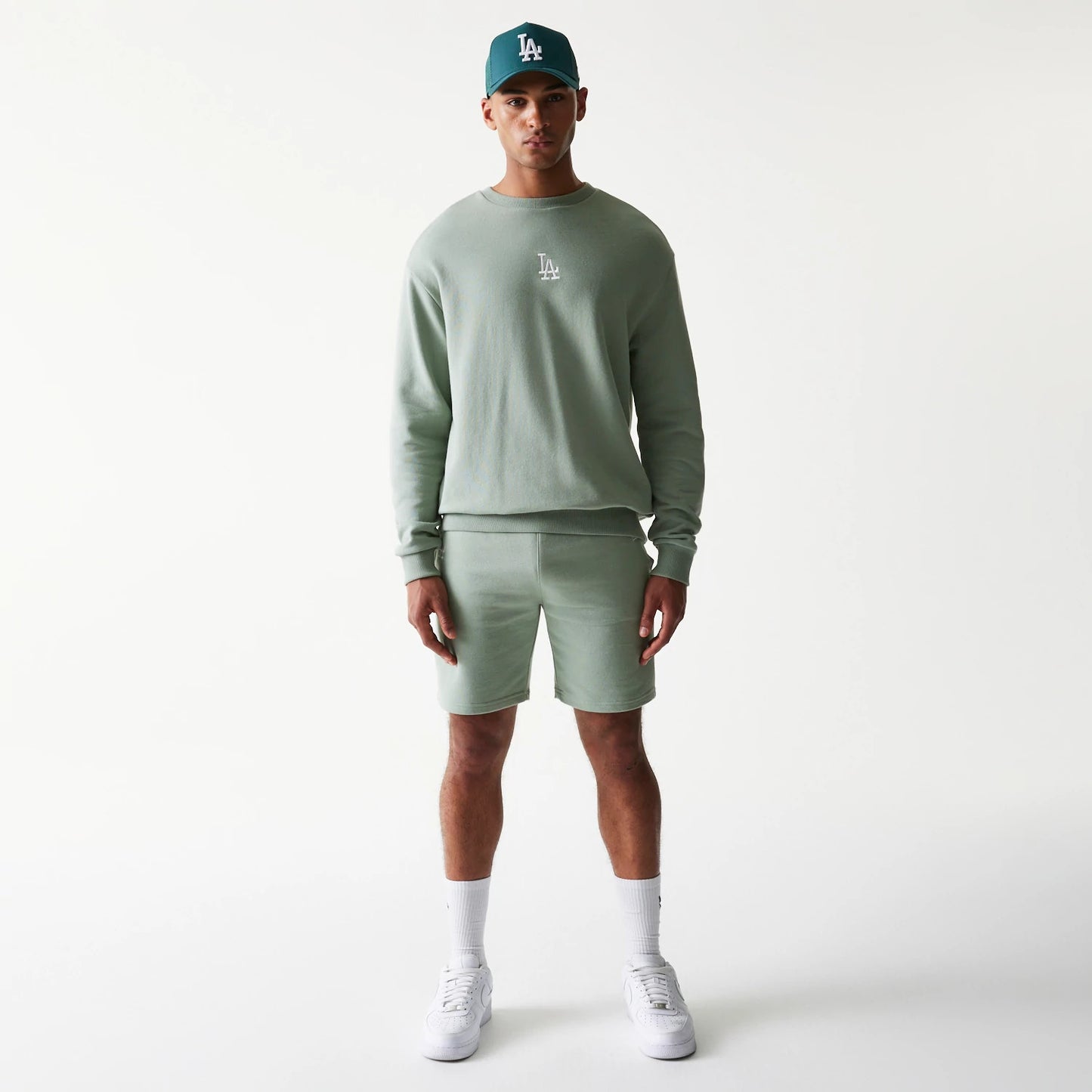 The model is wearing this MLB League Essential Midi LA Dodgers Shorts in green. 8