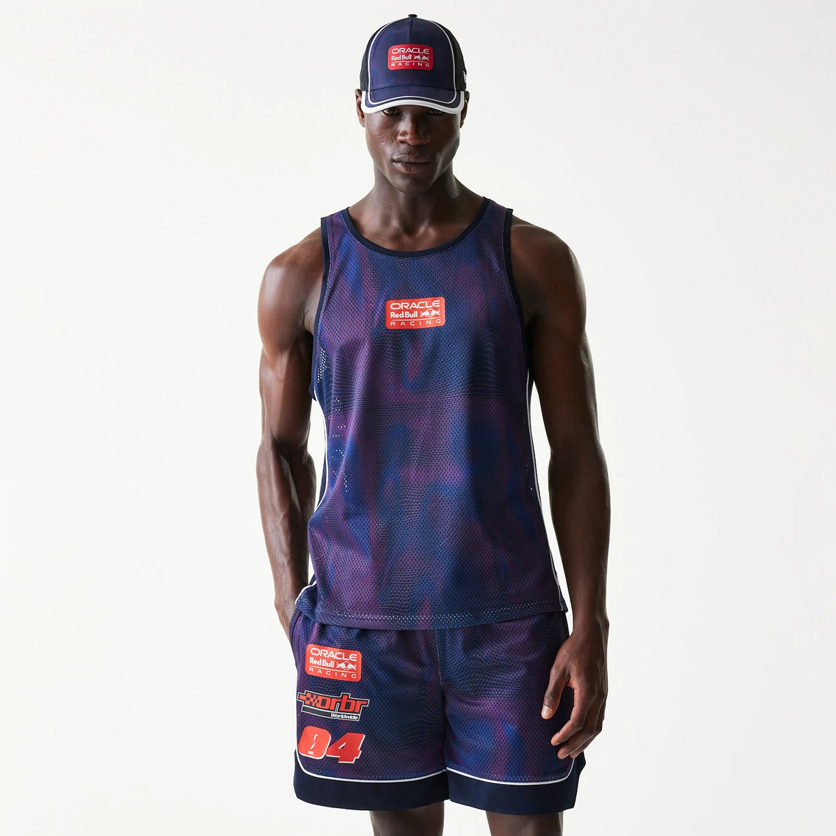New Era Red Bull Racing Dark Blue Mesh Tank Top, front view on a model showing the red and white Oracle logo patch centred on the chest, in a relaxed fit with wide armholes and a round neckline.
