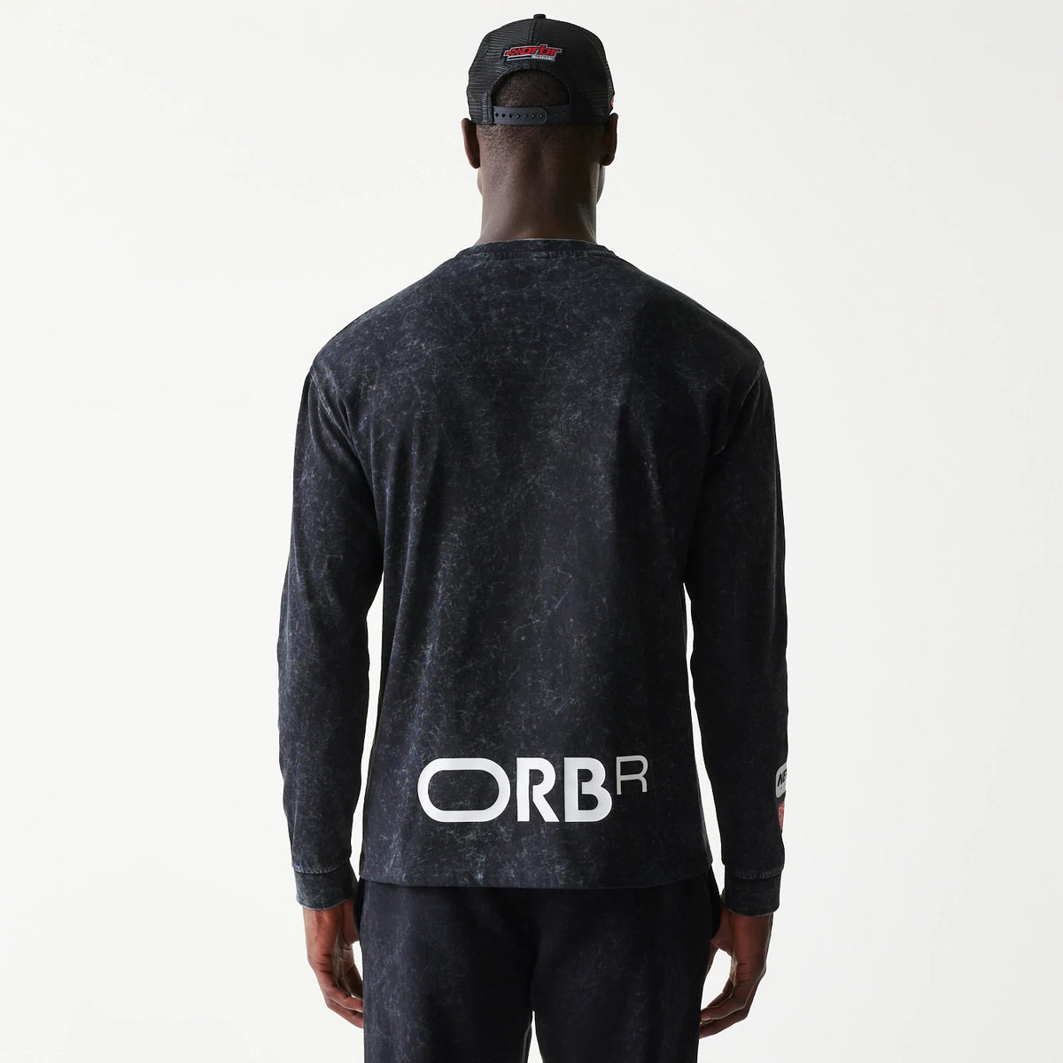 The model is wearing this Red Bull Racing Linear Graphic Long Sleeve T-Shirt in black. 2