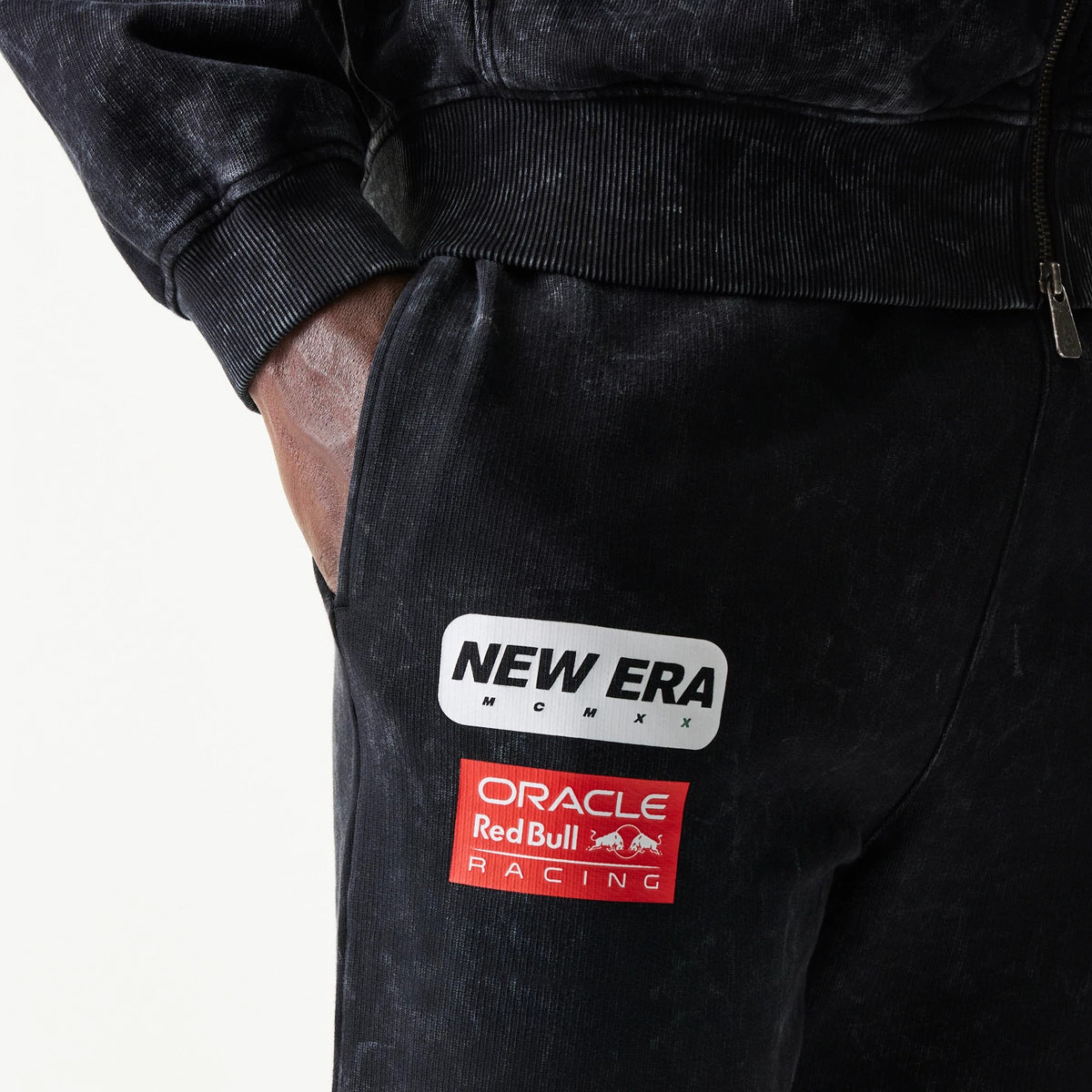 New Era Red Bull Racing Straight Leg Black Straight Leg Joggers, close-up showing the New Era MCMXX patch above the Oracle Red Bull Racing logo on the upper left leg, with a pocket seam.