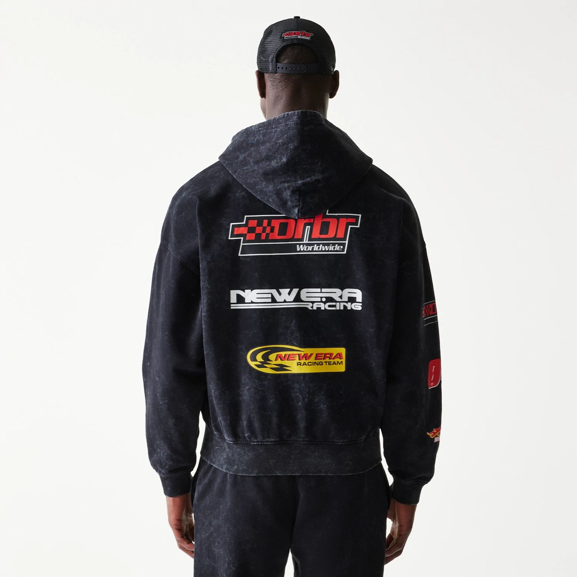The model is wearing this Red Bull Racing Graphic Dropped Shoulder Full Zip Hoodie in black. 2