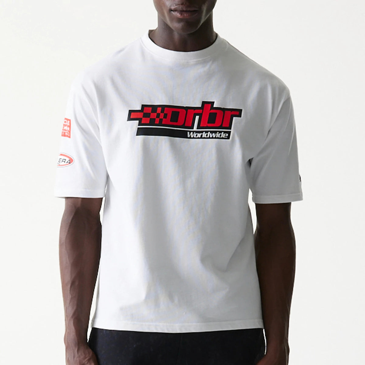 New Era Red Bull Racing Graphic White Oversized T-Shirt, front view on a model showing a large red and black graphic with text Rbr Worldwide emblazoned across the chest and a printed New Era logo on the left sleeve.