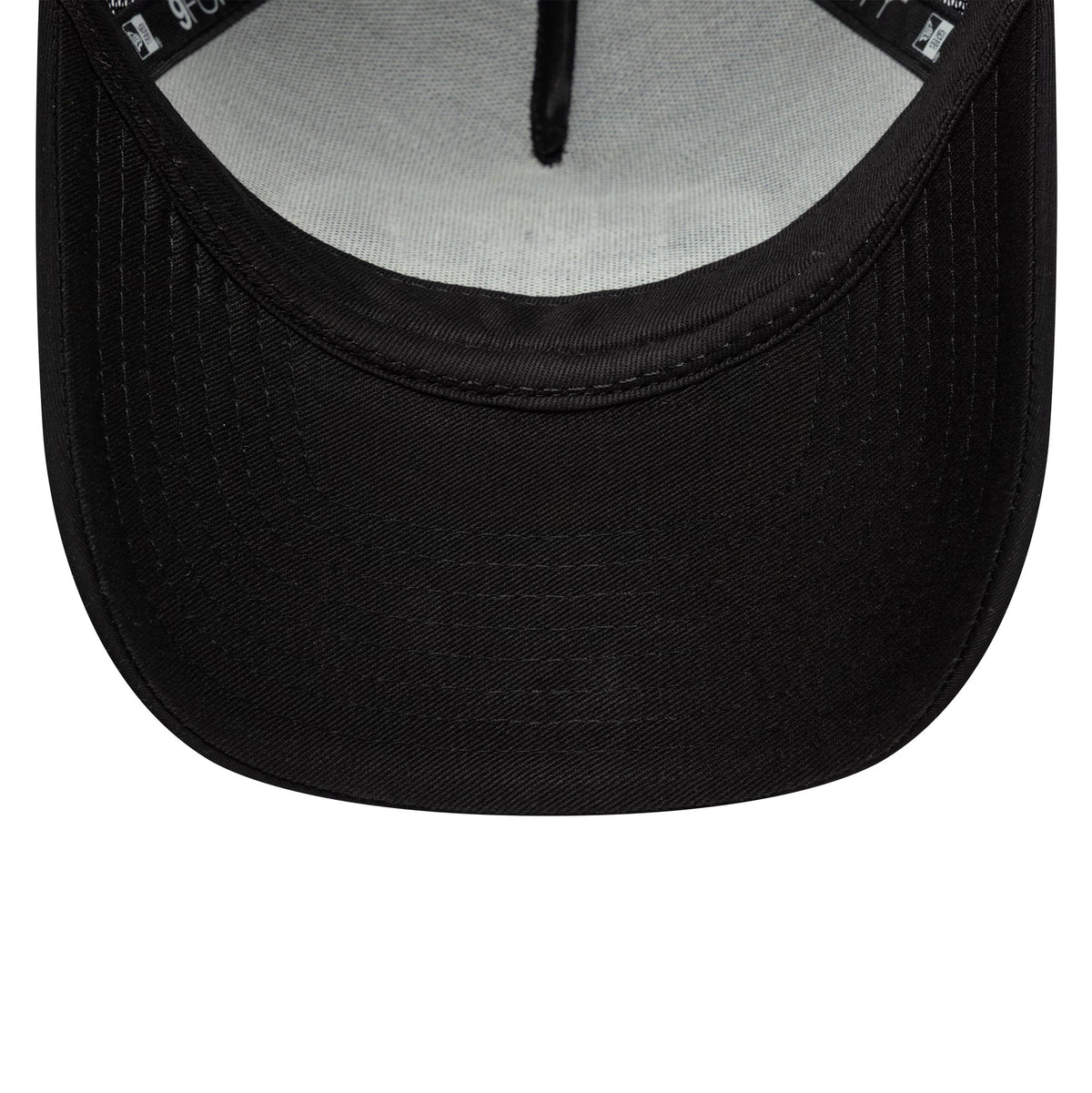 New Era Graphic Black 9FORTY M-Crown A-Frame Trucker Cap, inside view showing grey fabric undervisor, black sweatband with printed branding, and a curved black visor at the lower edge.