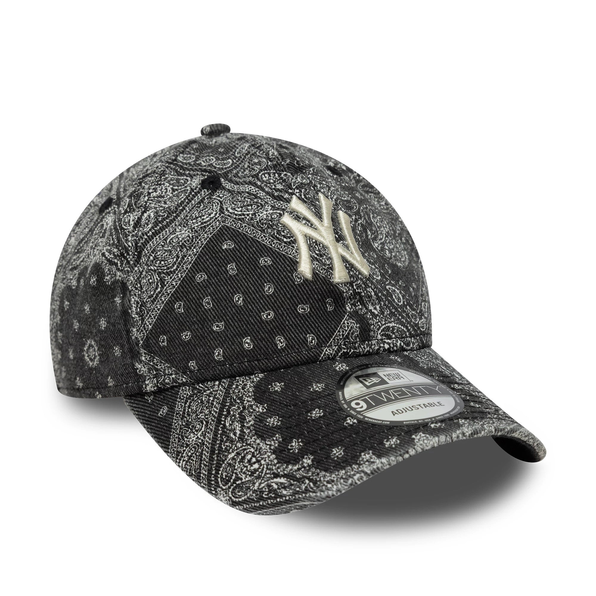 New York Yankees MLB Washed Paisley Black New Era 9TWENTY Cap, three-quarter view showing the beige embroidered NY logo on the front panel, a black curved visor with a 9TWENTY size sticker, and an intricate paisley pattern covering the entire cap.