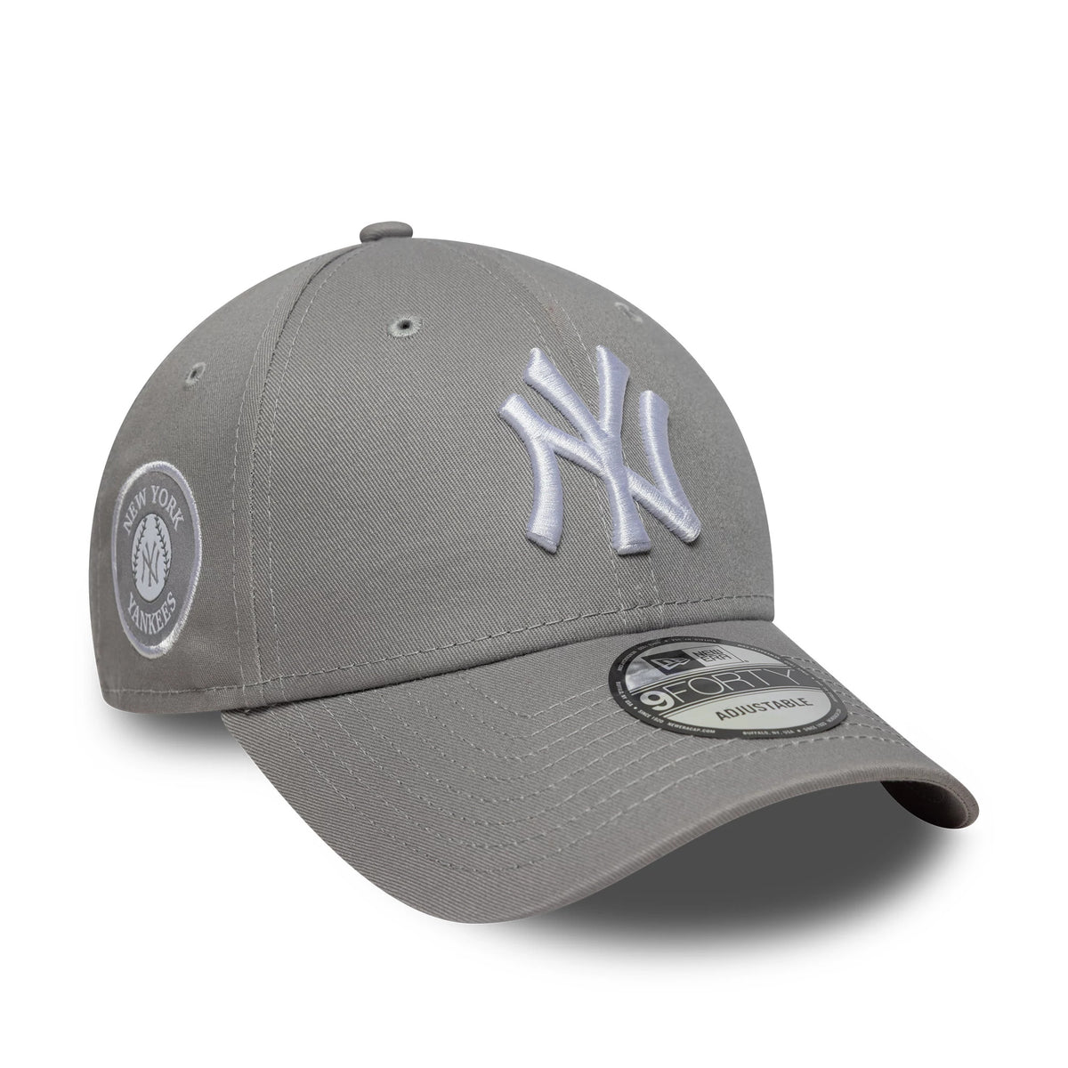 New York Yankees MLB Side Patch Grey New Era 9FORTY Cap, three-quarter view showing the raised white embroidered NY logo on the front panel, a grey curved visor with a 9FORTY size sticker, and a side patch with New York Yankees lettering.