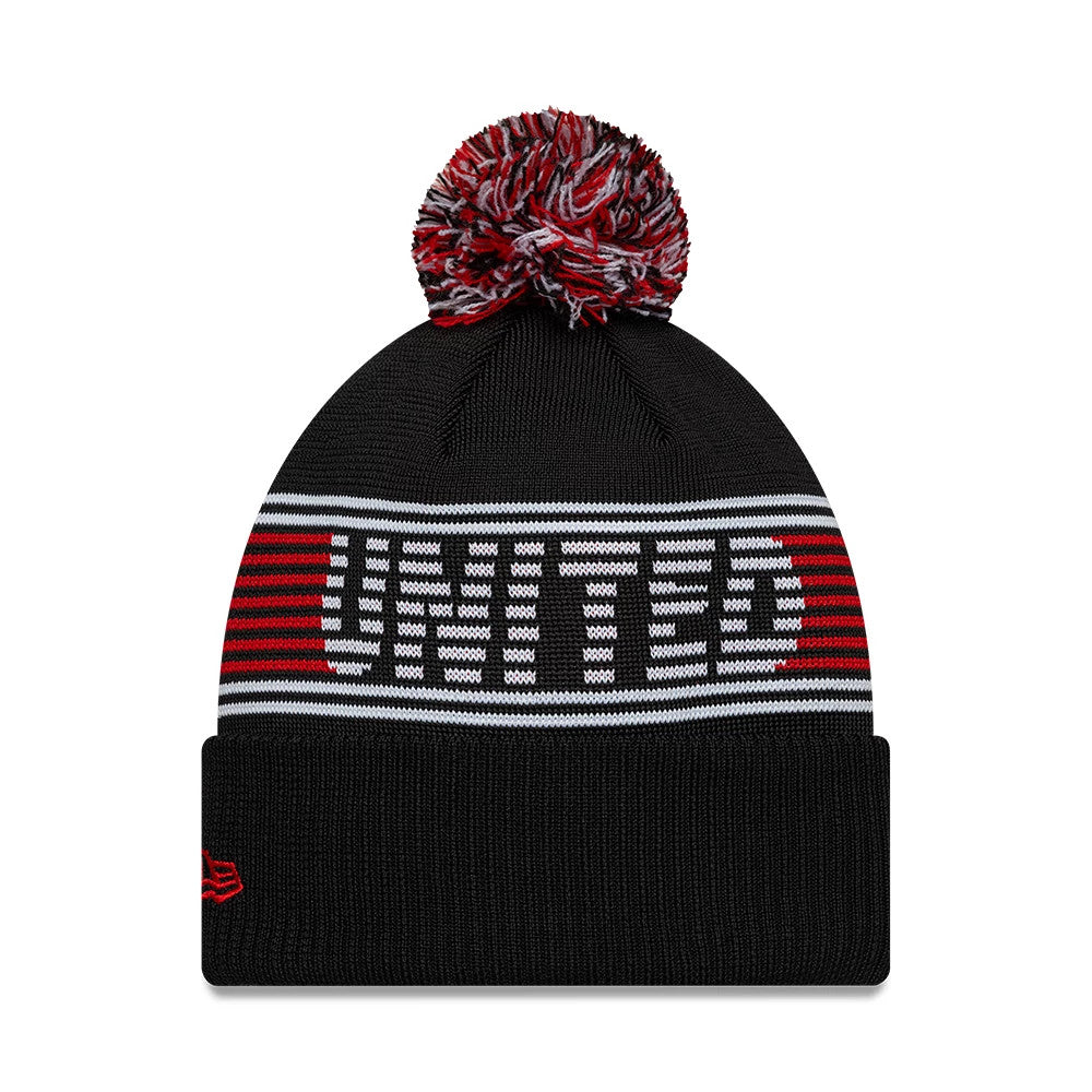 New Era Manchester United FC Black Bobble Knit Beanie Hat, front view showing the United text in red and white across the black crown, a multicoloured bobble on top, and an embroidered red New Era flag logo on the cuff.