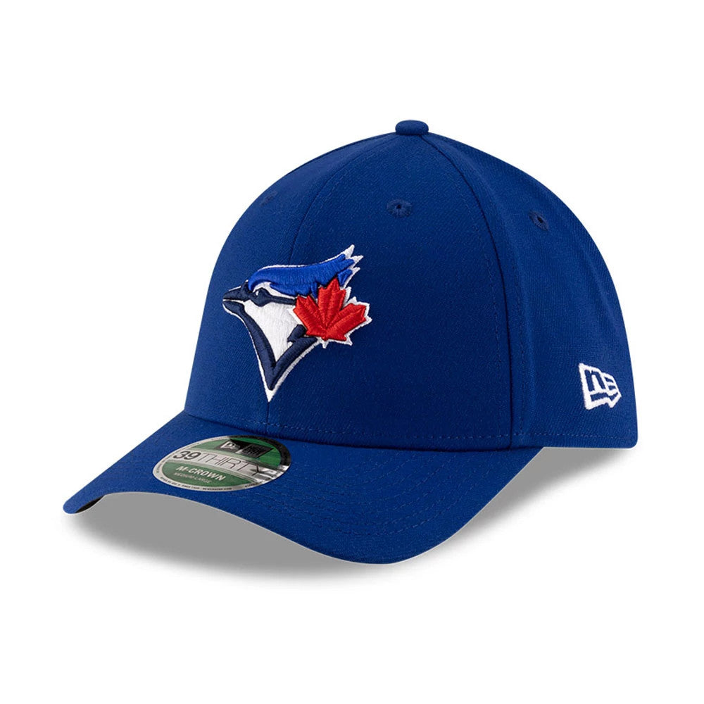 Blue Jays MLB Player Replica Blue New Era 39THIRTY M-Crown Stretch Fit Cap, three-quarter view showing the blue and red embroidered Blue Jays logo on the front panel, curved blue visor and New Era flag logo on the left side.