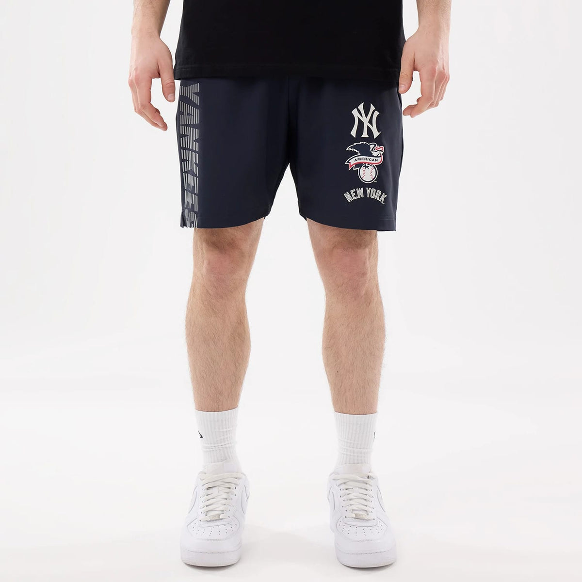 New Era New York Yankees MLB Match Navy Oversized Shorts, front view showing the white embroidered Yankees logo on the right leg, American League emblem below, and vertical grey Yankees lettering on the left side.