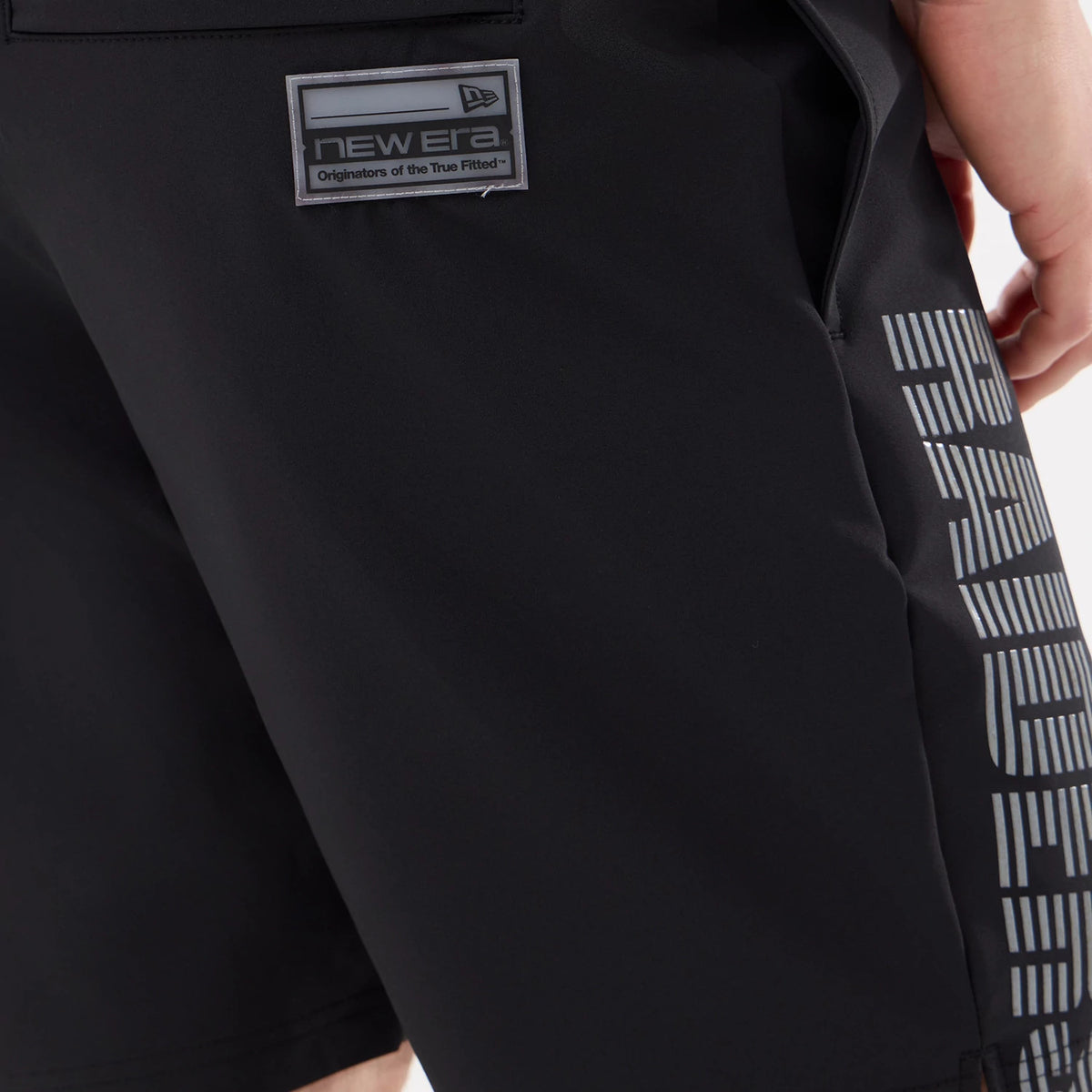 New Era Las Vegas Raiders NFL Match Black Oversized Shorts, side view showing the white Raiders lettering vertically down the leg, a printed New Era logo patch above the pocket, and a clean black colour throughout.