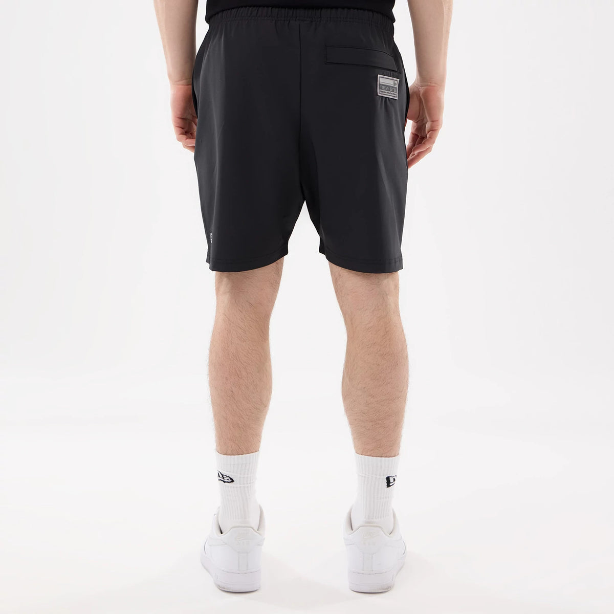New Era Las Vegas Raiders NFL Match Black Oversized Shorts, back view showing a single pocket with a rectangular patch near the top right and the New Era logo embroidered at the bottom left edge on the black fabric.