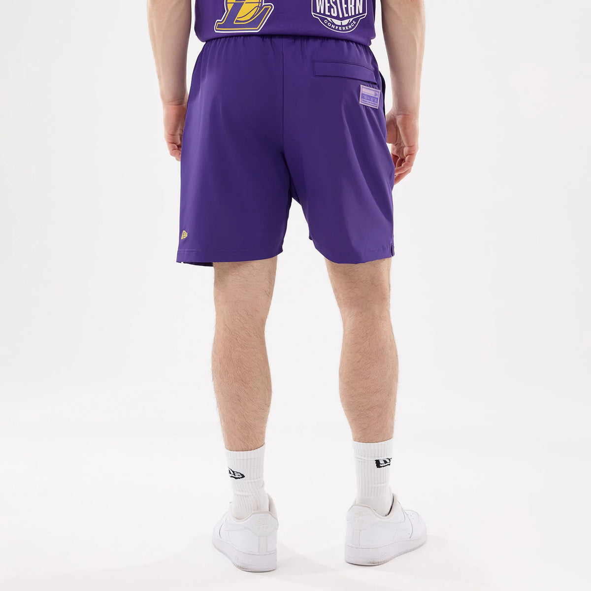 New Era LA Lakers NBA Match Purple Oversized Shorts, back view showing a patch pocket on the right side, an embroidered New Era logo near the hem, and the elastic waistband providing a comfortable fit.