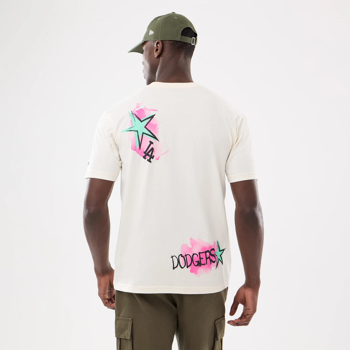 New Era LA Dodgers MLB Street Art Graphic Light Beige T-Shirt, back view on a model showing a large star and LA logo graphic on the upper back in green and pink tones, with the word Dodgers below in similar style.