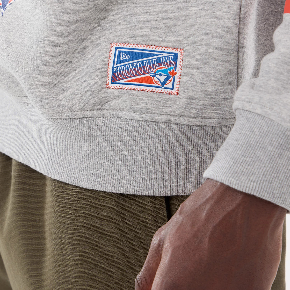 The model is wearing this MLB Sport Classic Toronto Blue Jays Crew Neck Sweater in grey. 4