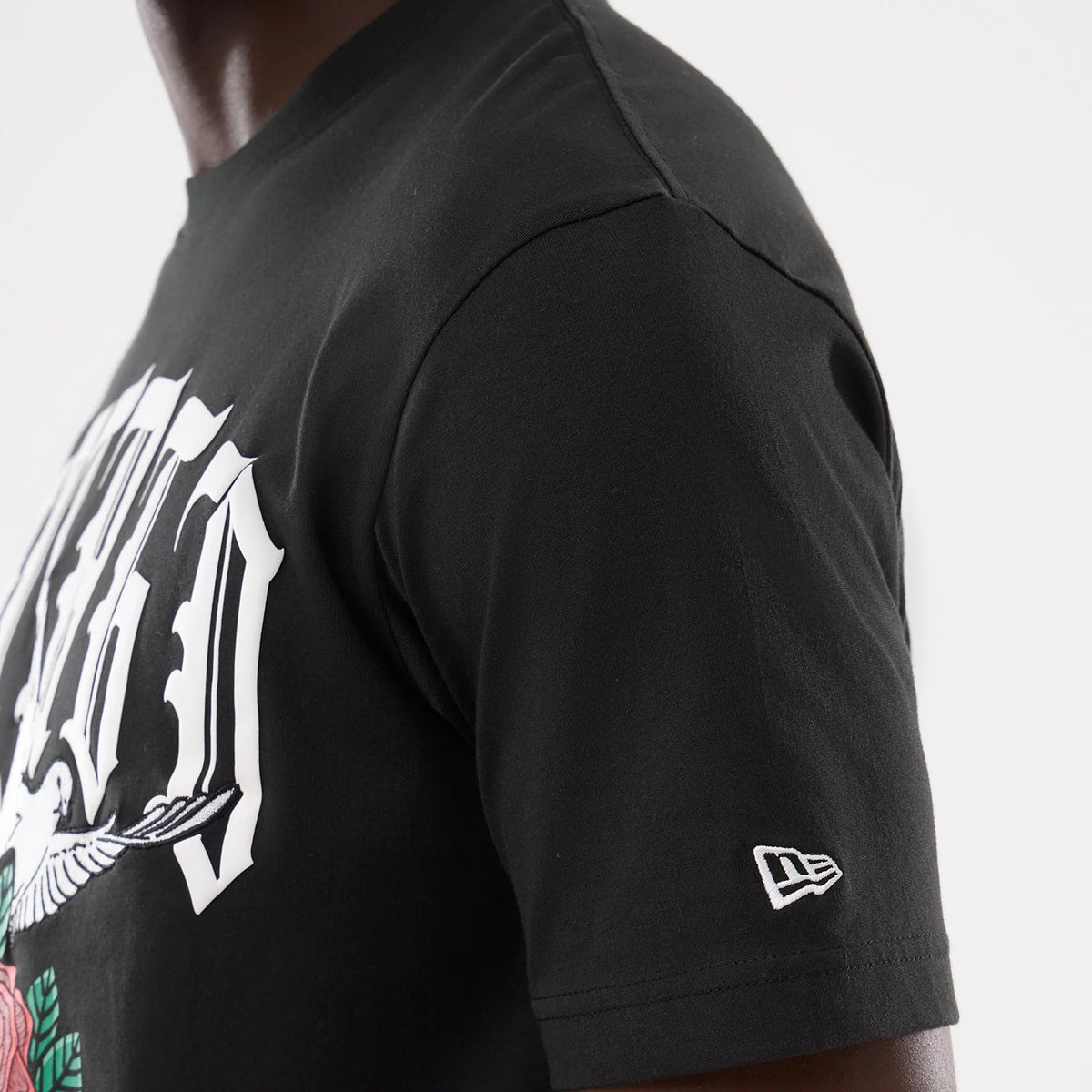 New Era Chicago White Sox MLB Script Graphic Black T-Shirt, three-quarter view showing a white embroidered New Era logo on the left sleeve and a large white graphic with floral elements on the chest.