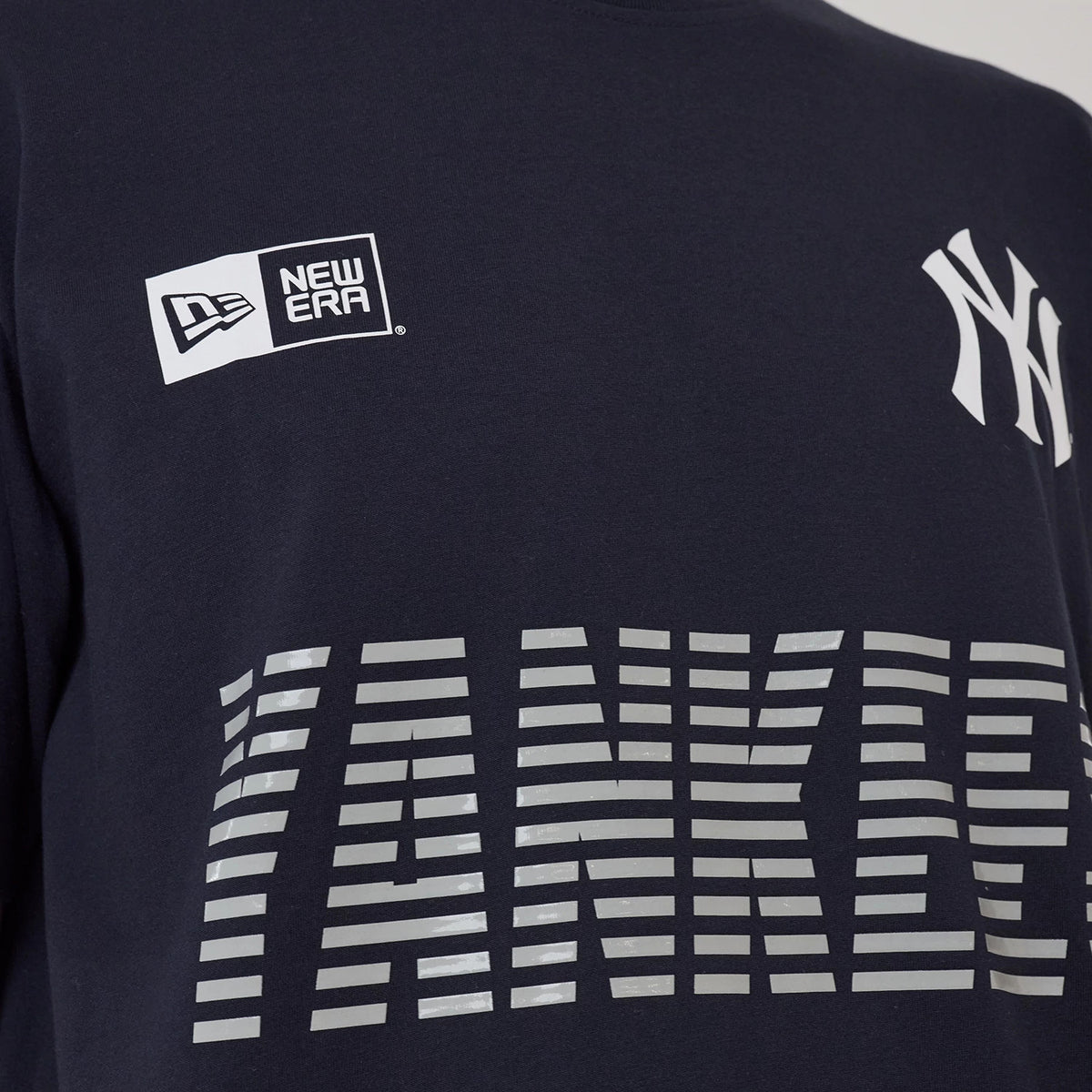 New Era New York Yankees MLB Match Navy T-Shirt, front view showing the grey Yankees lettering across the chest with a printed New Era logo on the upper left and the Yankees logo on the upper right side.