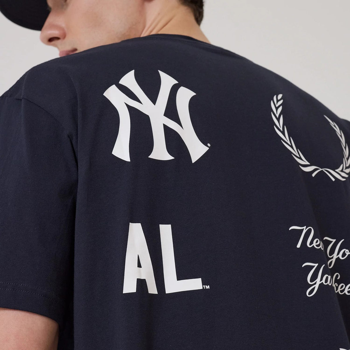 New Era New York Yankees MLB Match Navy T-Shirt, back view showing the large white printed Yankees logo near the shoulder, additional white graphics including AL lettering and decorative elements across the navy fabric.