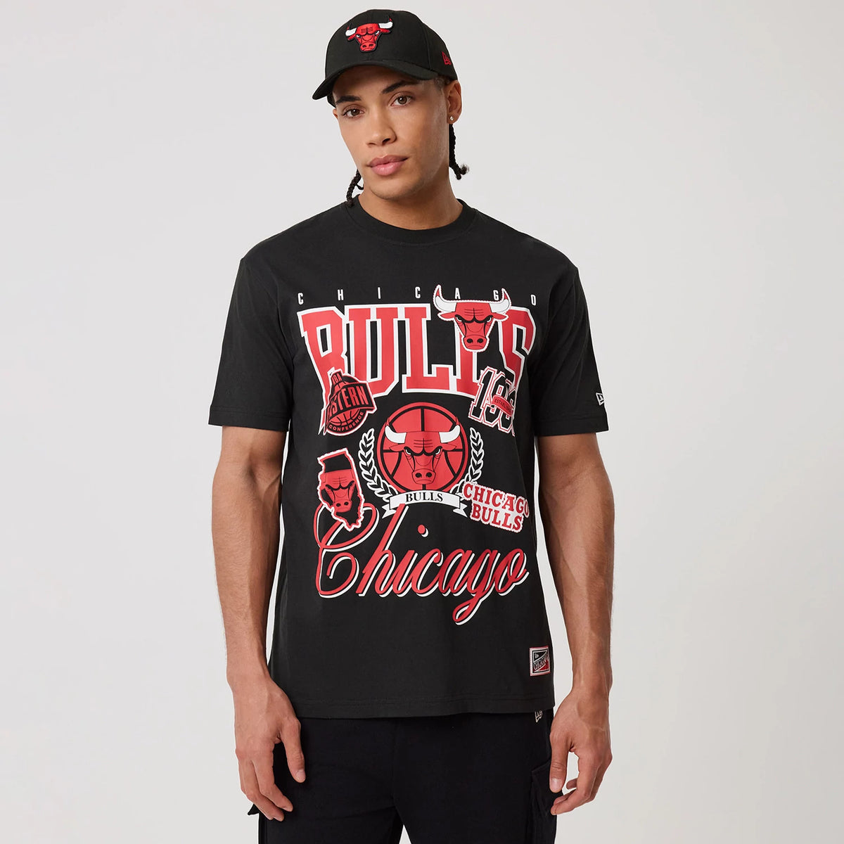 New Era Chicago Bulls NBA Sport Classic Black T-Shirt, front view on-model showing large red Bulls graphics and lettering across the chest, with a small embroidered New Era logo on the left sleeve.
