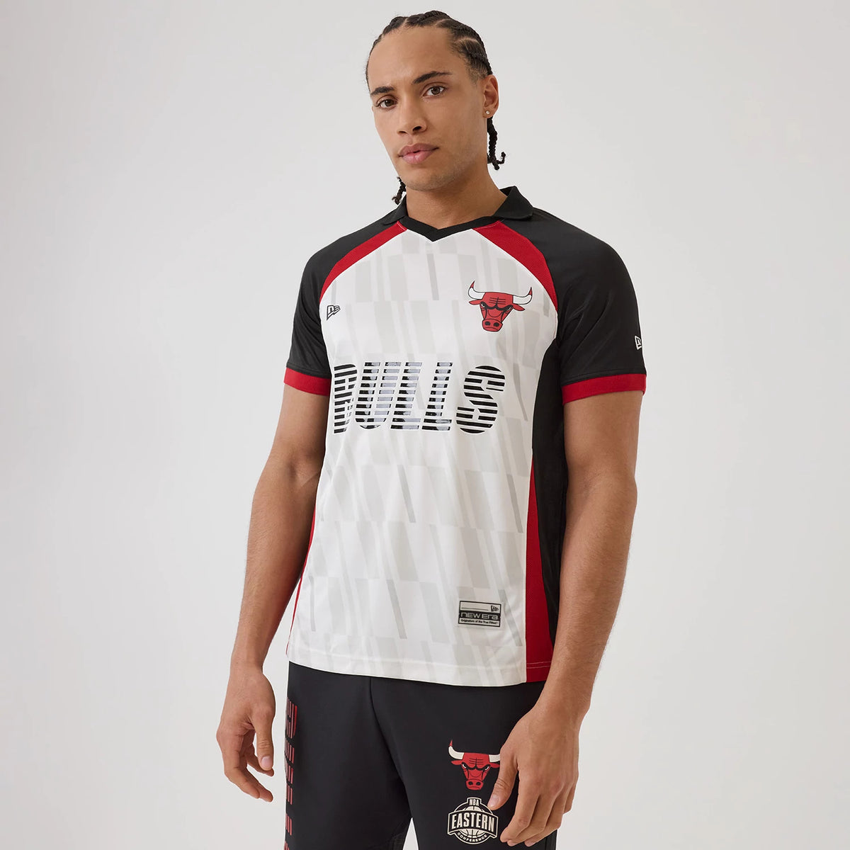 New Era Chicago Bulls NBA Match White T-Shirt, front view on a model highlighting the black Bulls lettering across the chest, a red and black Bulls logo on the upper left side, and contrasting black and red panels on the sleeves and sides.