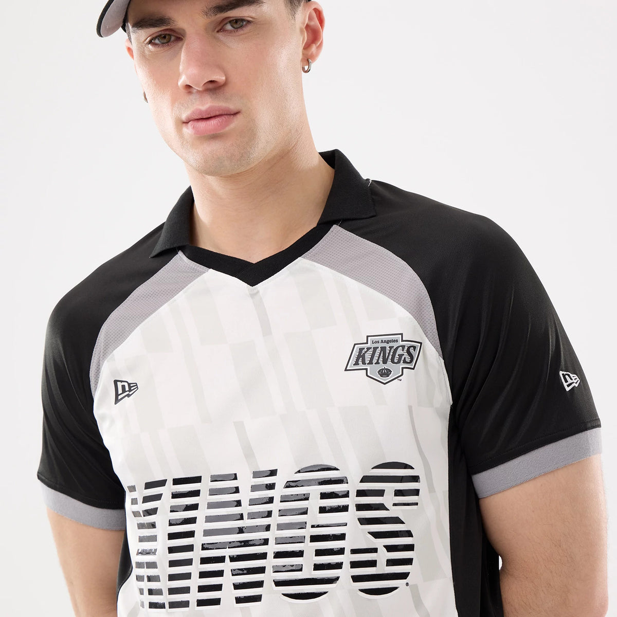 New Era LA Kings NHL Match Black T-Shirt, front view showing the Kings logo on the upper left chest, KINGS lettering across the chest, New Era logo embroidered on the left sleeve, styled here worn with a black cap.