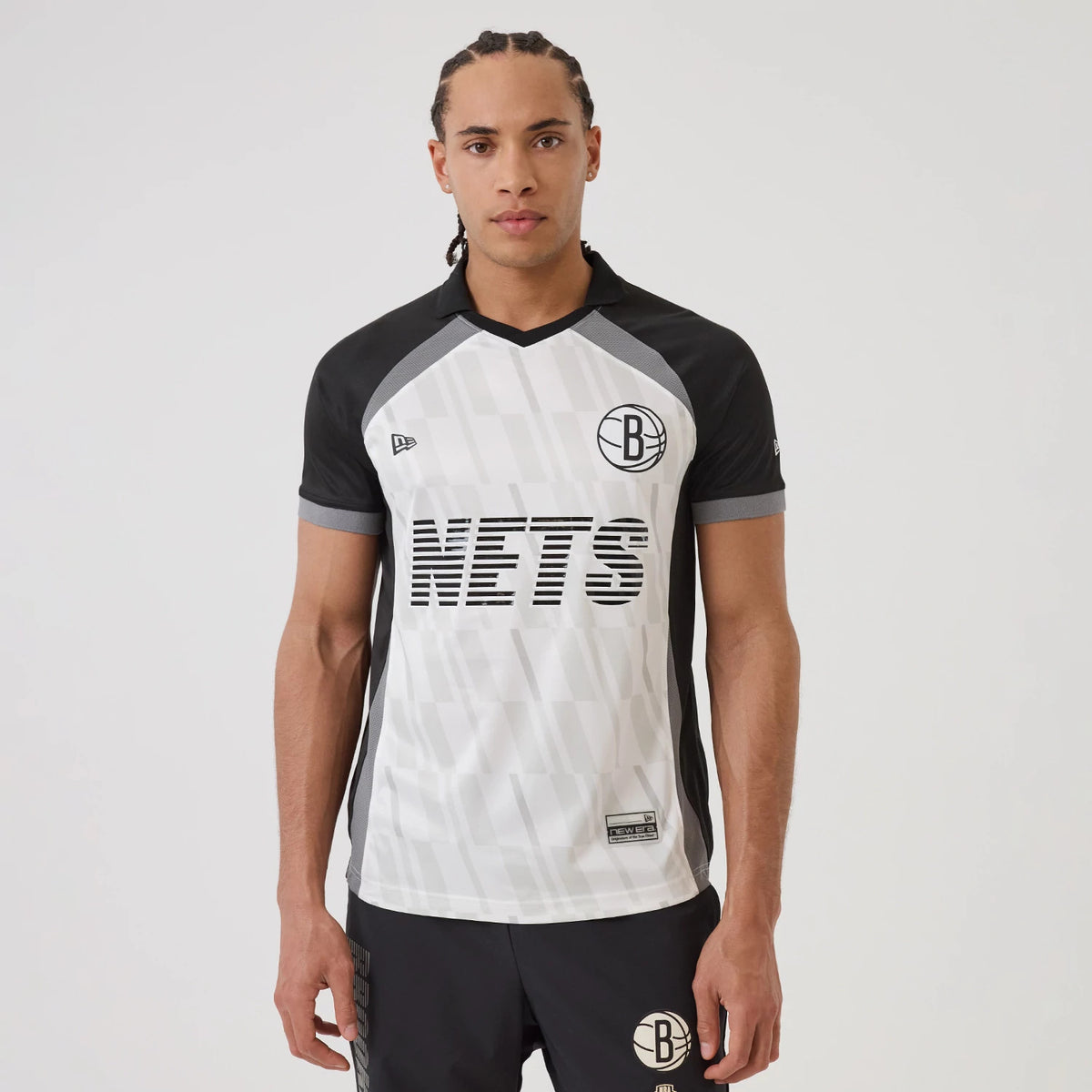 New Era Brooklyn Nets NBA Match Black T-Shirt, front view showing black NETS lettering across the centre, black and white panelled design with the New Era logo embroidered on the left chest and the team emblem on the right chest.