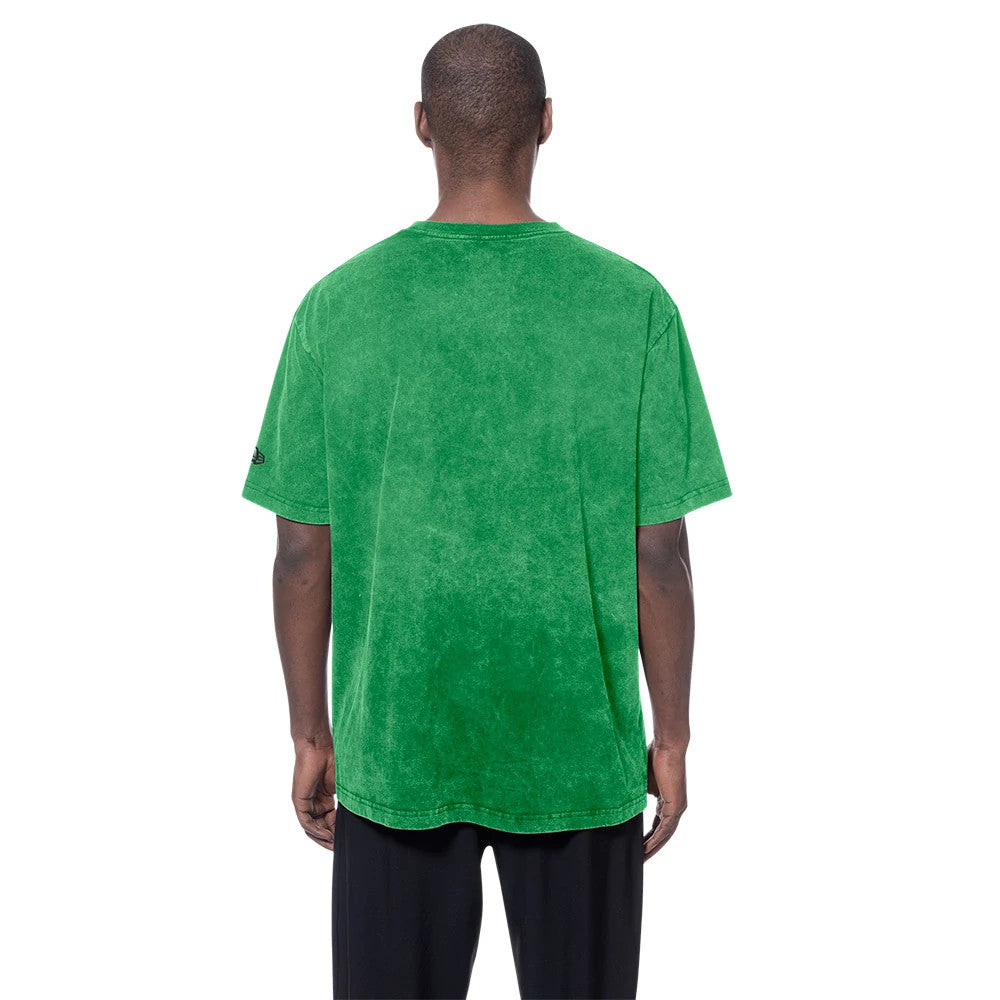 New Era Boston Celtics NBA Green T-Shirt, back view on a model wearing the green t-shirt, showing a plain back with a small embroidered New Era logo on the left sleeve, styled with black trousers.