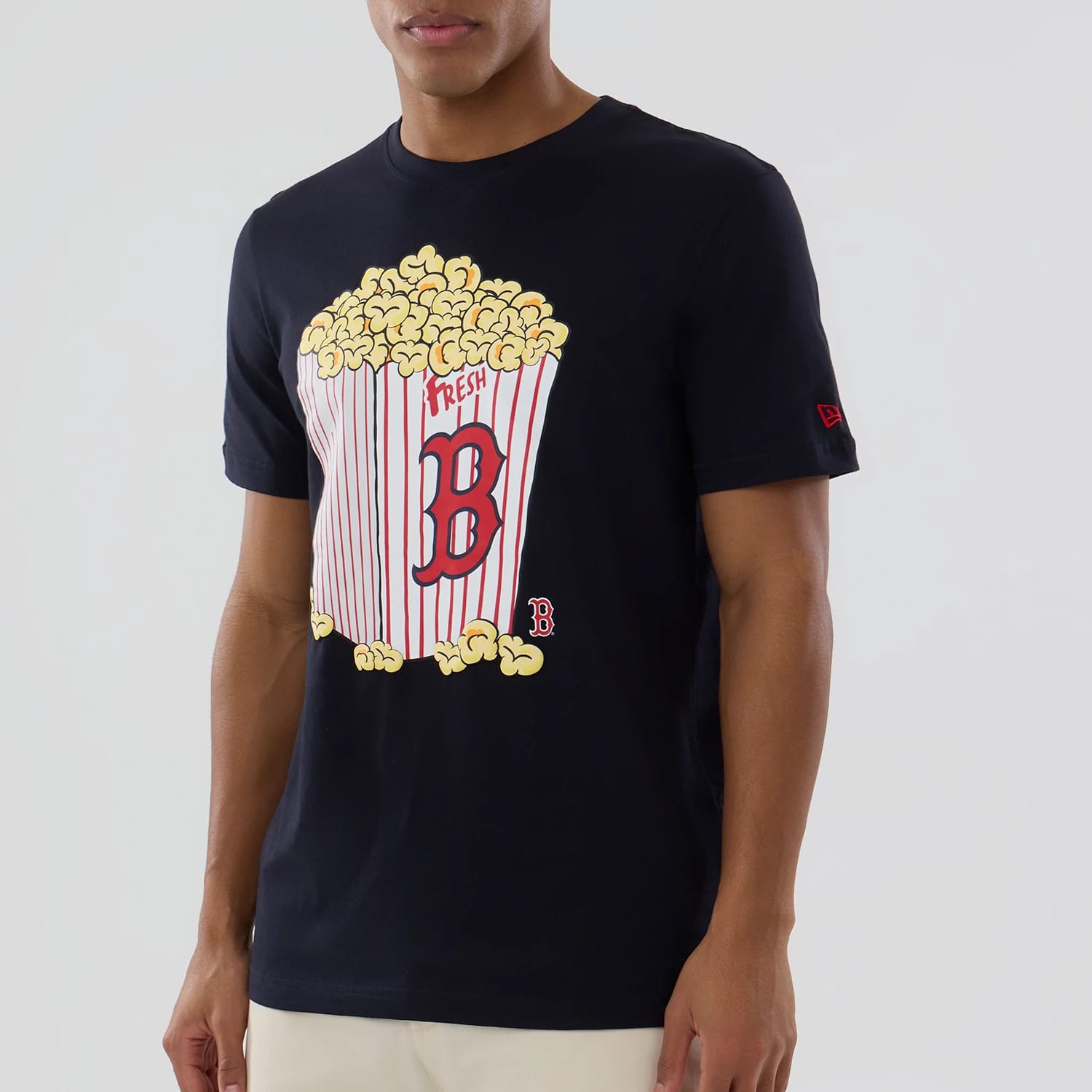 New Era Boston Red Sox MLB Popcorn Navy T-Shirt, front view on-model showing a large printed graphic of overflowing popcorn in a red and white striped container with the letter B, and a small embroidered New Era logo on the sleeve.