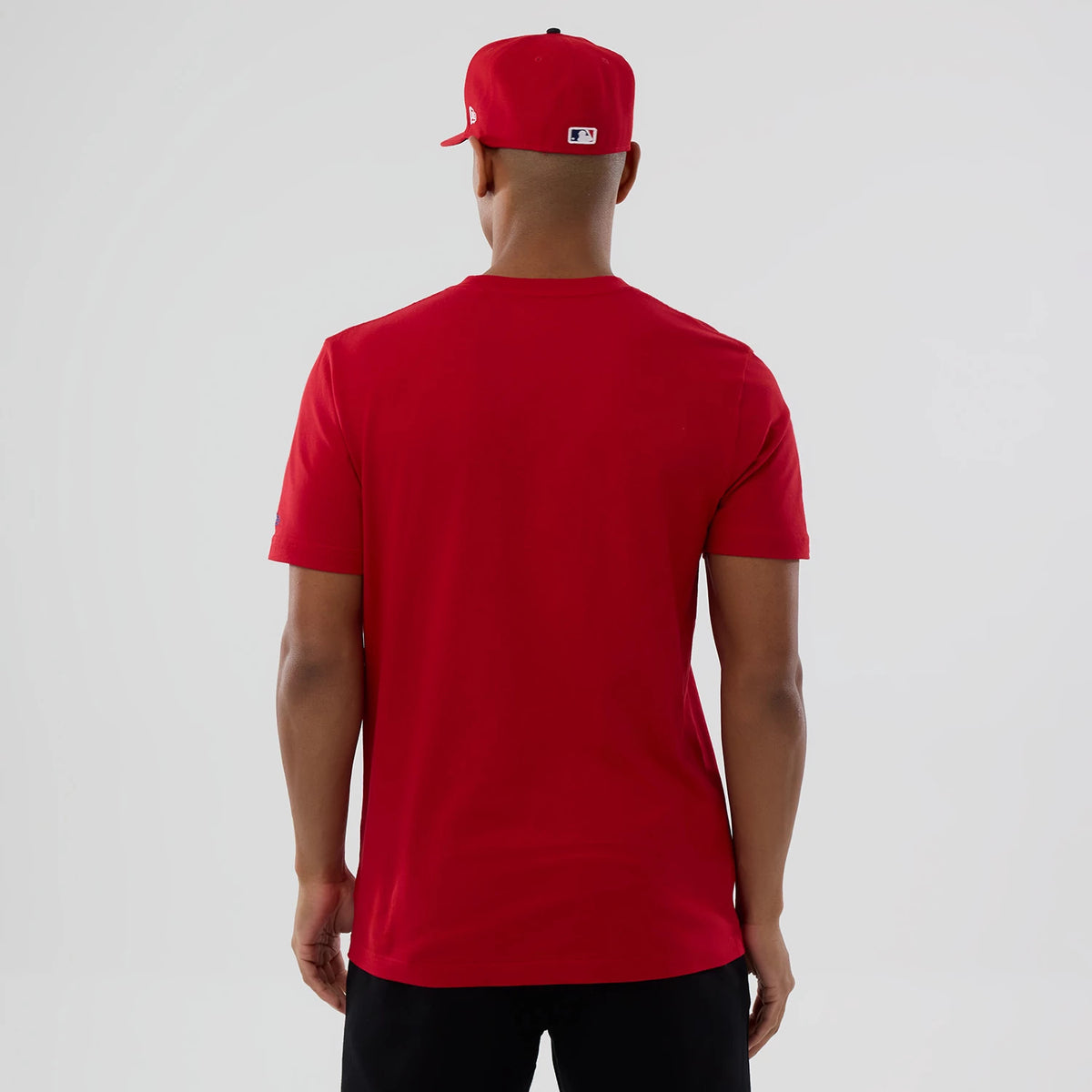 New Era Philadelphia Phillies MLB Popcorn Red T-Shirt, back view showing a plain red design with no graphics or lettering, styled with a matching red cap displaying an embroidered MLB logo at the rear.