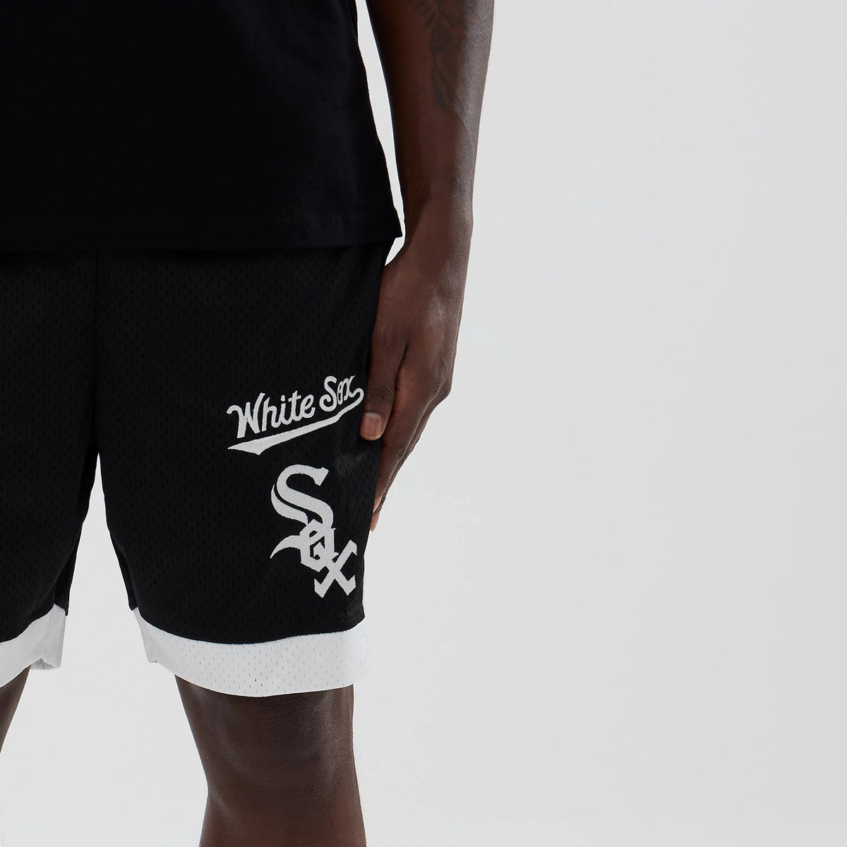 New Era Chicago White Sox MLB Black Mesh Shorts, front view showing the white embroidered White Sox script and logo on the left leg, with contrasting white trim at the hem and texture throughout.