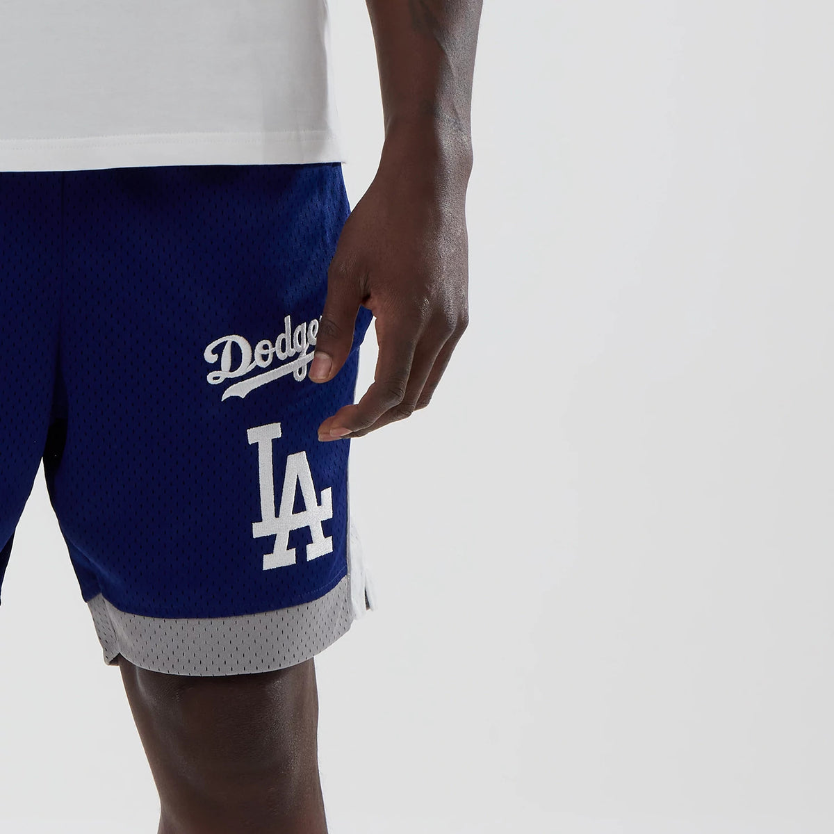New Era LA Dodgers MLB Dark Blue Mesh Shorts, front view on-model showing embroidered Dodgers script logo on the right leg and large LA logo below, featuring a grey trim at the hem with a side split detail.