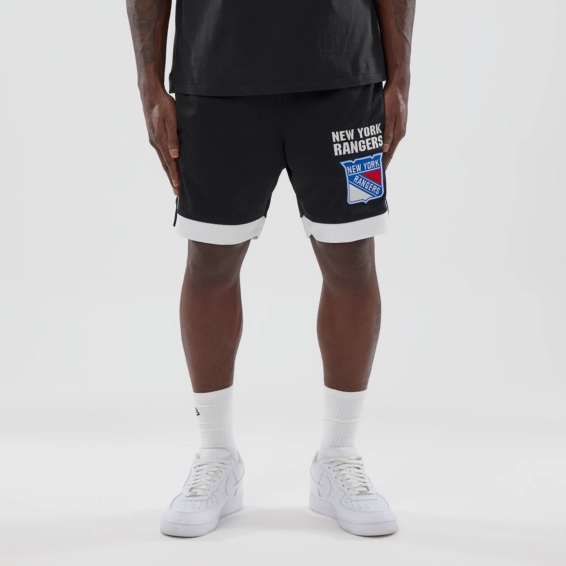 The model is wearing these NHL New York Rangers Mesh Shorts in black. 1