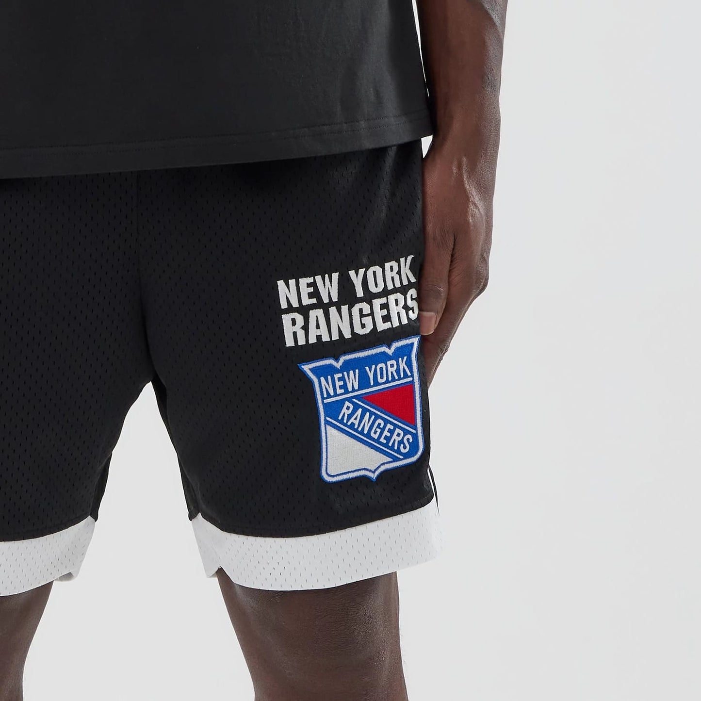 The model is wearing these NHL New York Rangers Mesh Shorts in black. 4