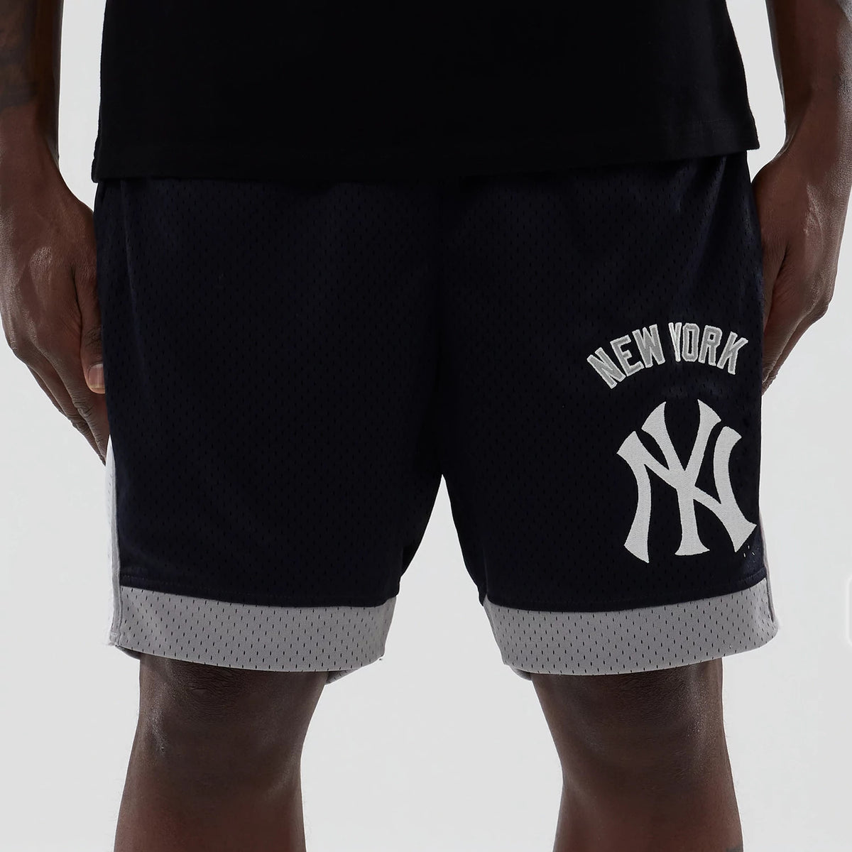 New Era New York Yankees MLB Navy Mesh Shorts, front view showing large white printed New York Yankees logo on the left thigh, with grey trim at the hem and New York text arched above the logo, styled with a black top.