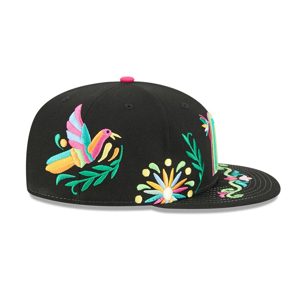 Mexico WBC Latin Embroidery Black New Era 59FIFTY Fitted Cap, side view showing colourful embroidered patterns including a bird, flower, and stripes on the visor, all on a structured black crown with a pink top button.