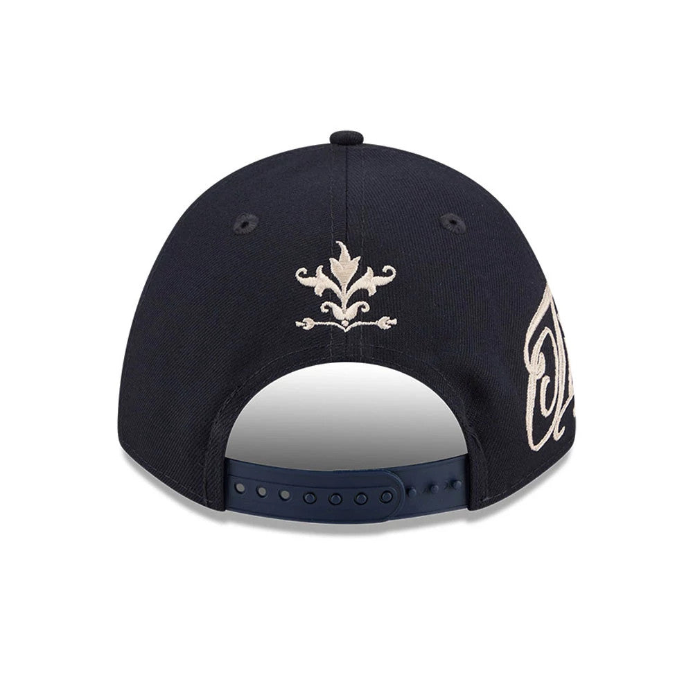 Detroit Tigers MLB Script Navy New Era 9FORTY M-Crown A-Frame Adjustable Cap, rear view showing the beige embroidered decorative emblem above the adjustable snap closure, with parts of the team logo on the side panel.