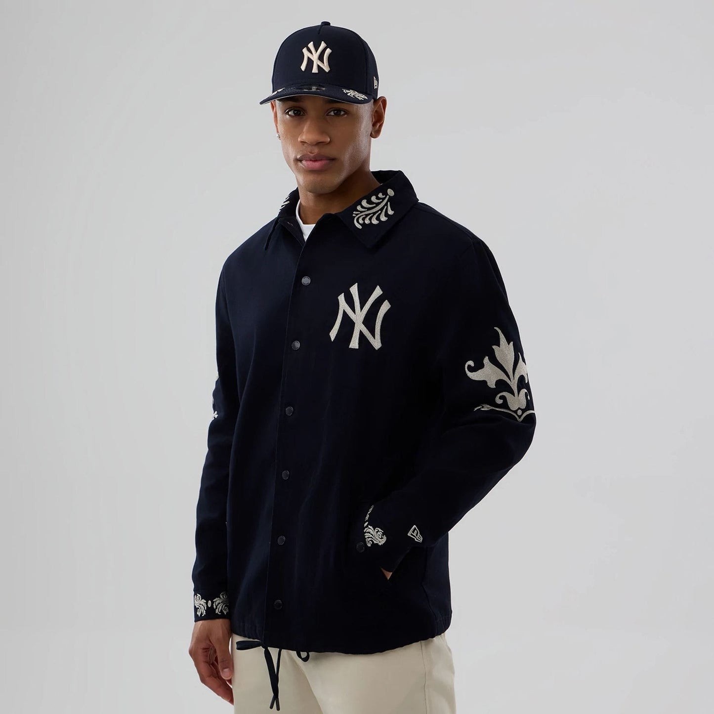 The model is wearing this MLB Script New York Yankees Coach Jacket in navy. 7