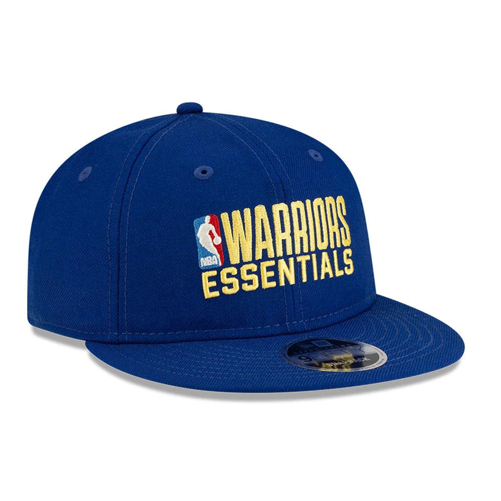 Golden State Warriors FOG x NBA Blue Retro Crown New Era 9FIFTY Adjustable Cap, three-quarter view showing the raised yellow Warriors Essentials embroidery with the NBA logo on the front panel and the 9FIFTY size sticker on the flat blue visor.
