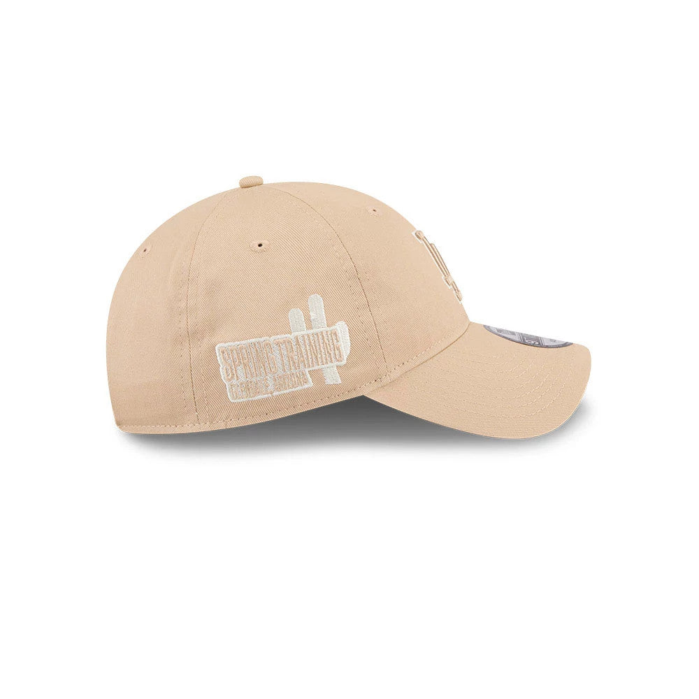LA Dodgers MLB Colours Light Beige New Era 9TWENTY Adjustable Cap, side view showing a white Spring Training graphic embroidered on the structured beige crown, with a gently curved visor and 9TWENTY size sticker.