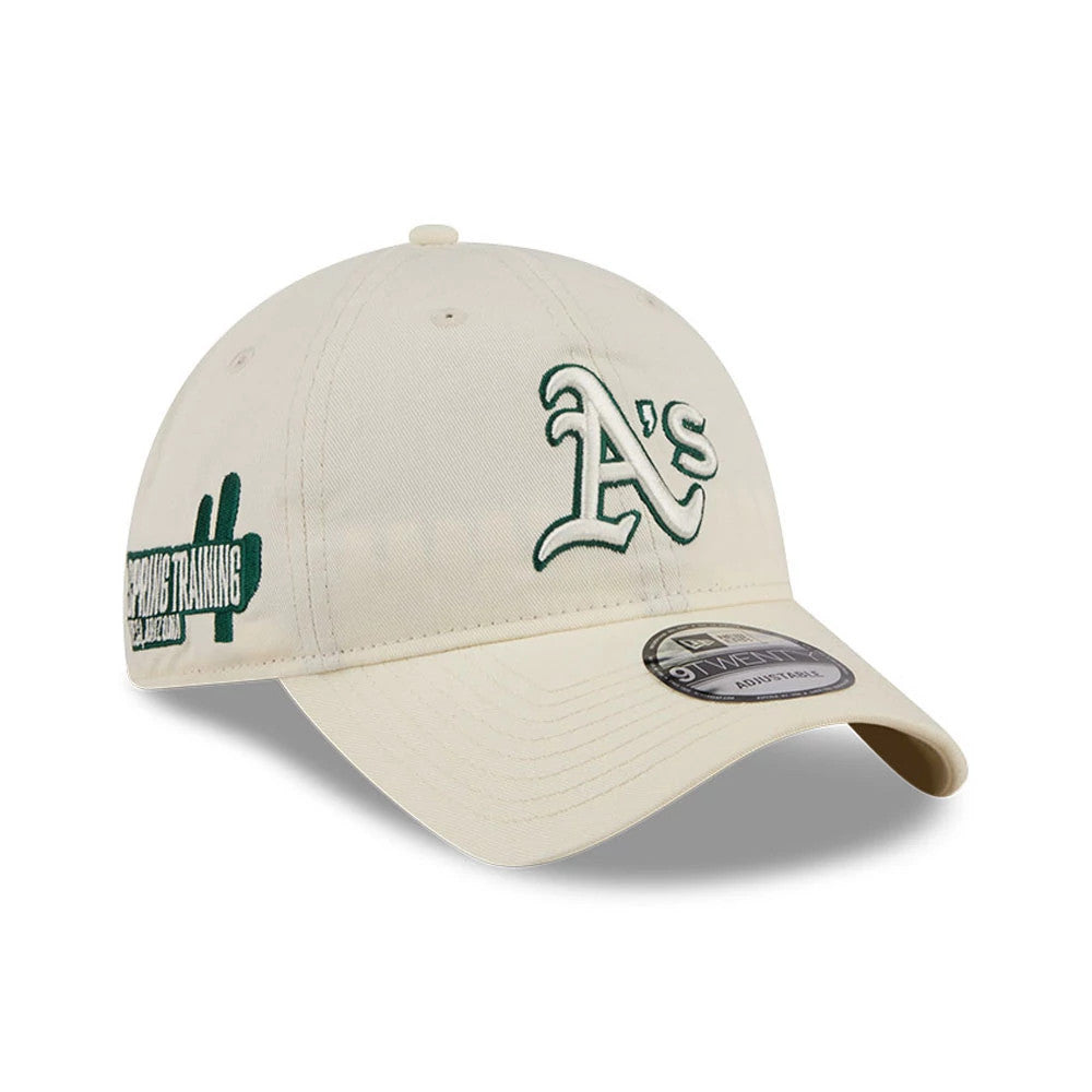 Athletics MLB Colours White New Era 9TWENTY Adjustable Cap, three-quarter view showing the green embroidered A's logo on the front panel, a Spring Training patch on the side, and a 9TWENTY size sticker on the curved visor.